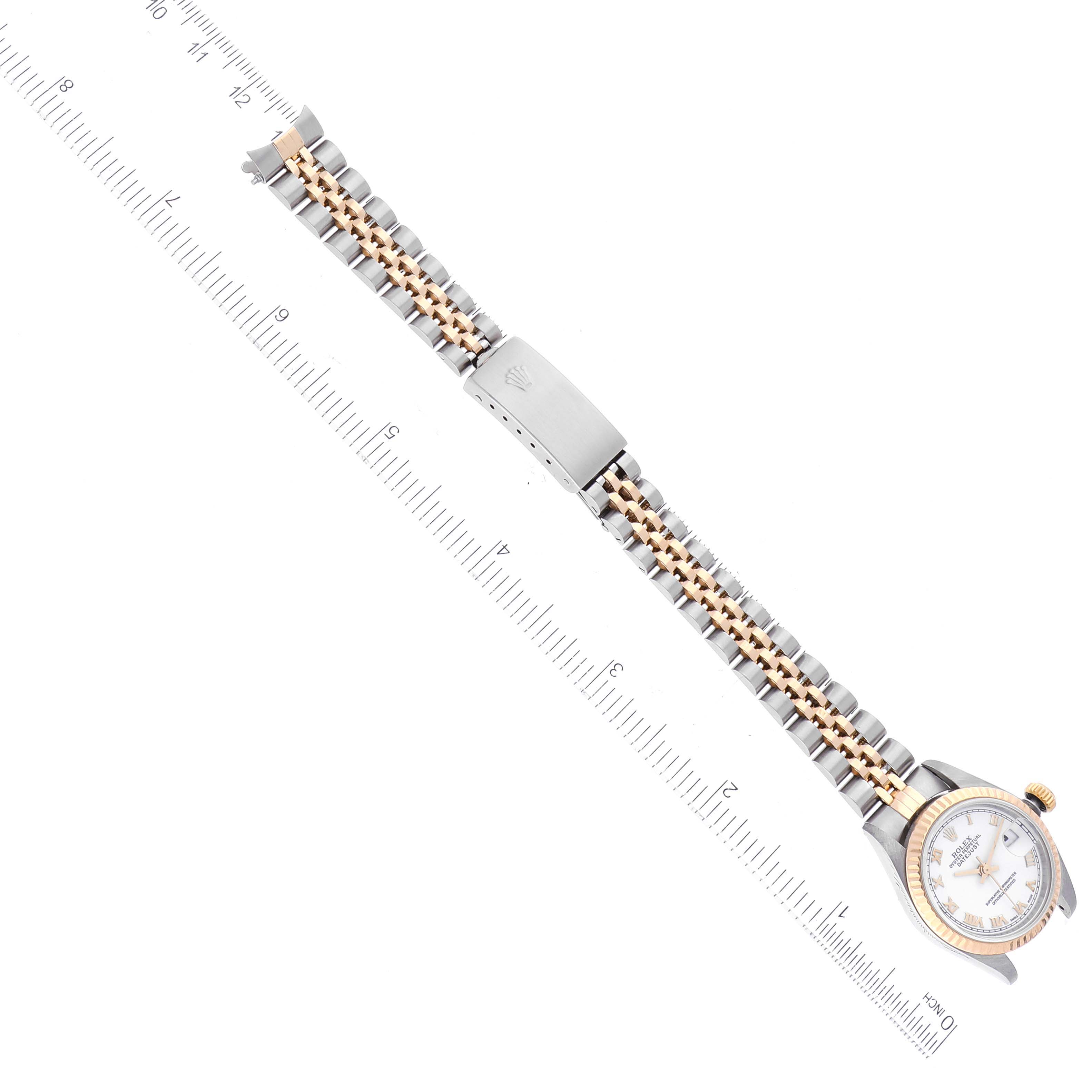 The image shows a top-down view of a Rolex Datejust 79173 Women's Steel and Gold (two tone) White Dial 79173 Women's Steel and Gold (two tone) White Dial watch with a ruler for scale, highlighting its bracelet and clasp.