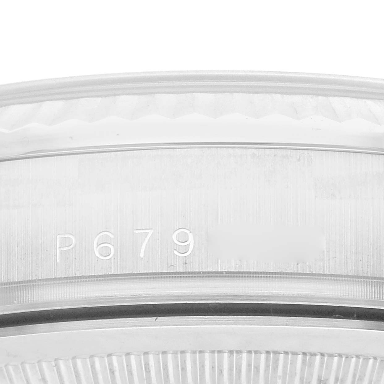 This image shows a close-up of the engraved serial number on the side of a Rolex President OFFICIALLY CERTIFIED CHRONOMETER SELF-WINDING MOVEMENT. Men's White Gold Silver Dial OFFICIALLY CERTIFIED CHRONOMETER SELF-WINDING MOVEMENT. Men's White Gold Silver Dial model watch case.