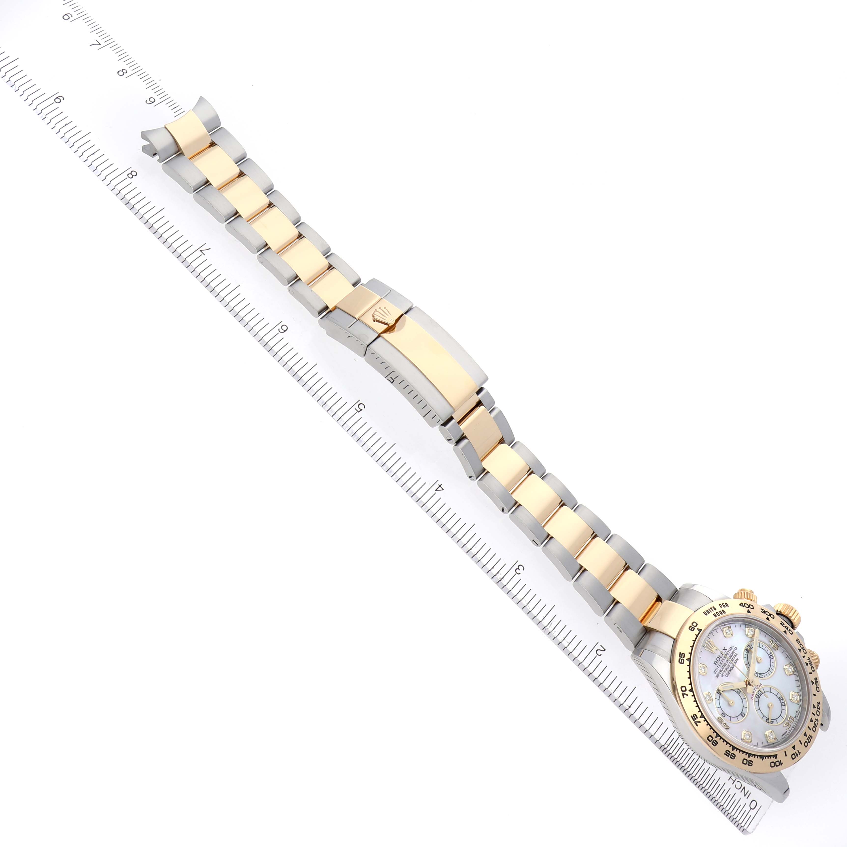 The image shows a Rolex Daytona 116503 Men
s Steel and Gold (two tone) Mother of Pearl Dial 116503 Men
s Steel and Gold (two tone) Mother of Pearl Dial watch laid flat with the bracelet extended and a ruler beside it.