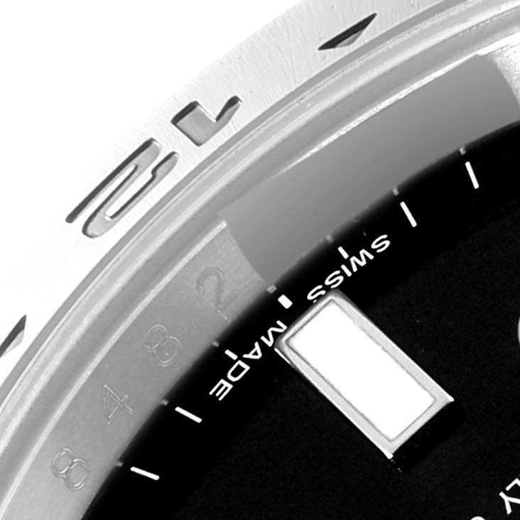 This close-up image of the Rolex Explorer 216570 Men
s Stainless Steel Black Dial 216570 Men
s Stainless Steel Black Dial watch model shows part of the bezel and the edge of the dial with the "Swiss Made" text.