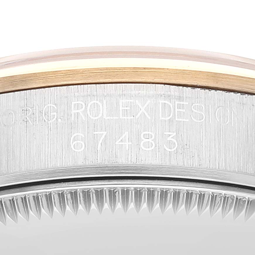 This close-up image shows the side of the Mid-Size Rolex watch case with engraved details and part of the bezel.