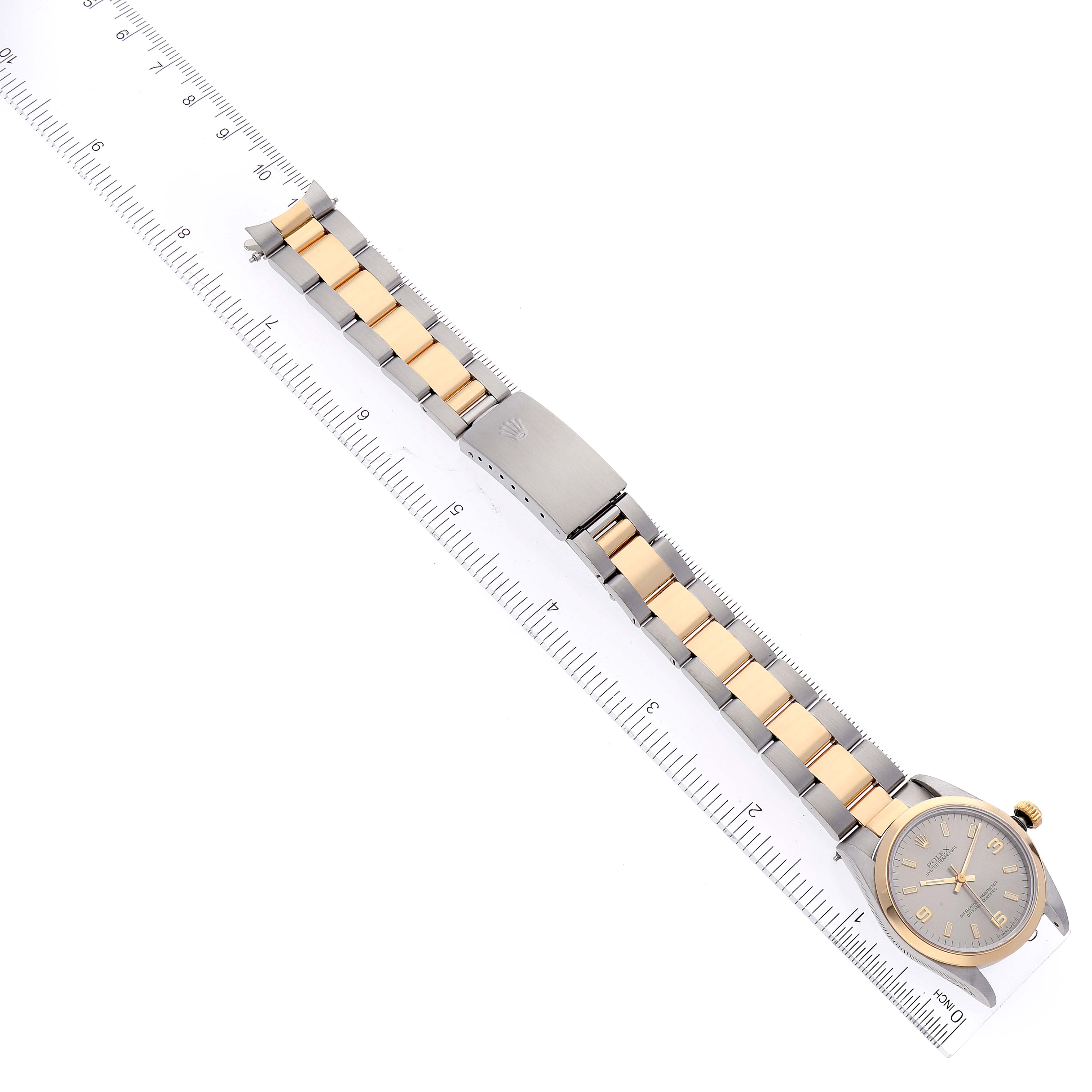 The image shows a Mid-Size Rolex watch laid flat, highlighting the full bracelet and clasp, alongside a ruler for measurement.