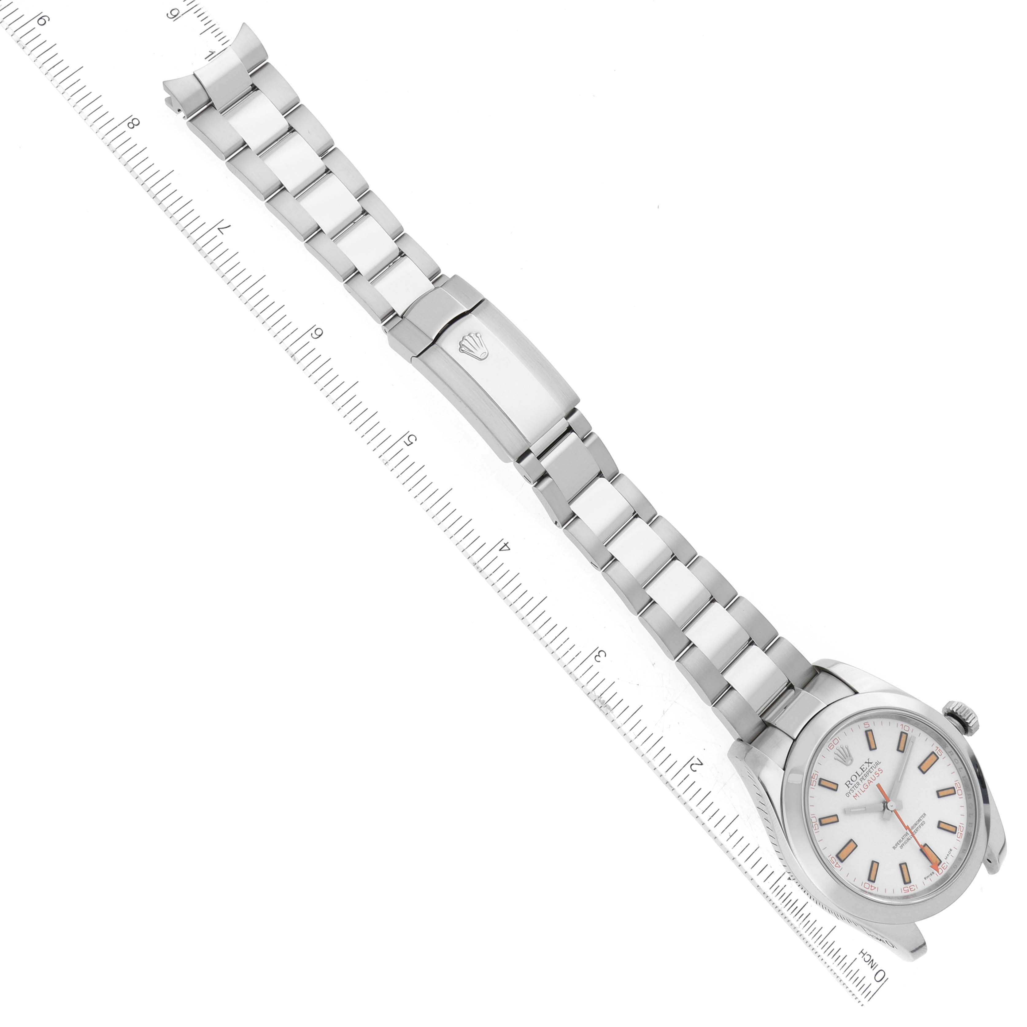 The image shows a top-down view of a Rolex Milgauss 116400 Men's Stainless Steel White Dial 116400 Men's Stainless Steel White Dial watch displaying the face, bracelet, and clasp, placed next to a ruler.