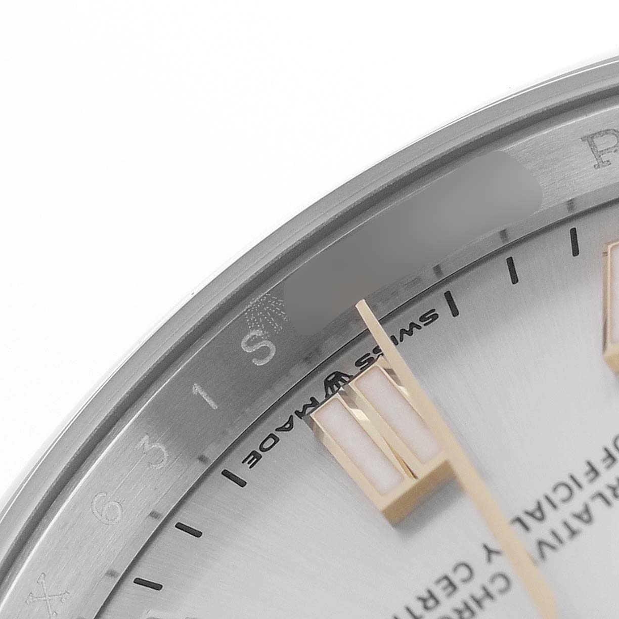 The image shows a close-up of the dial and bezel of a Rolex Oyster Perpetual 126000 Men's Stainless Steel Silver Dial, highlighting the indices and text details.