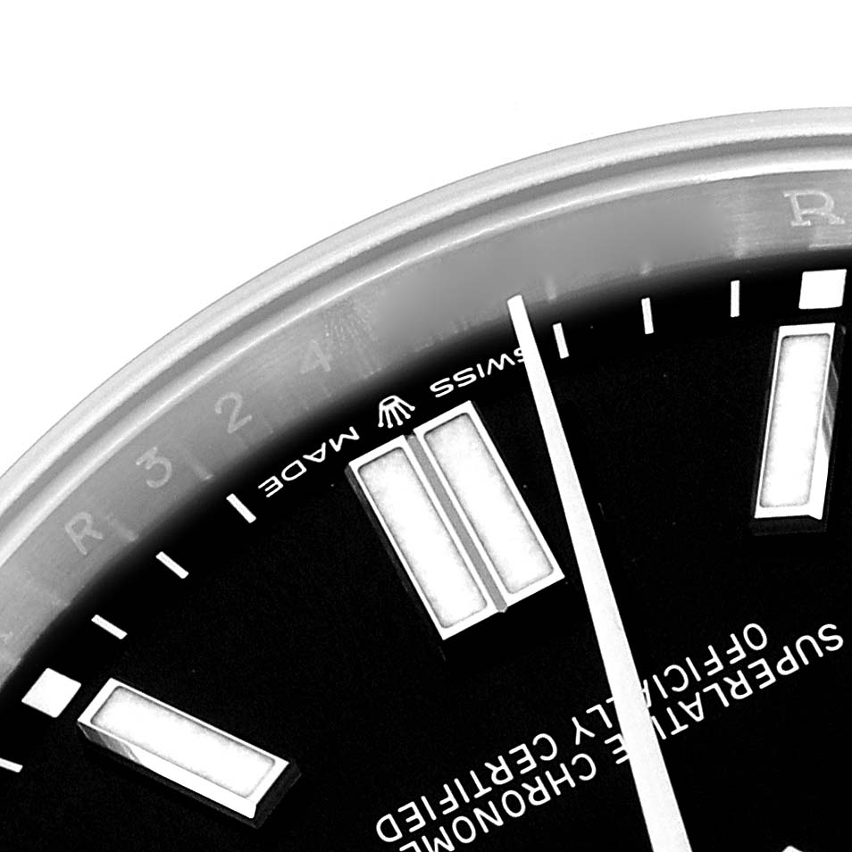 The image shows the upper left part of the Rolex Oyster Perpetual 124300 Men's Stainless Steel Black Dial 124300 Men's Stainless Steel Black Dial watch face, including the "Swiss Made" text, hour markers, and minute hand.