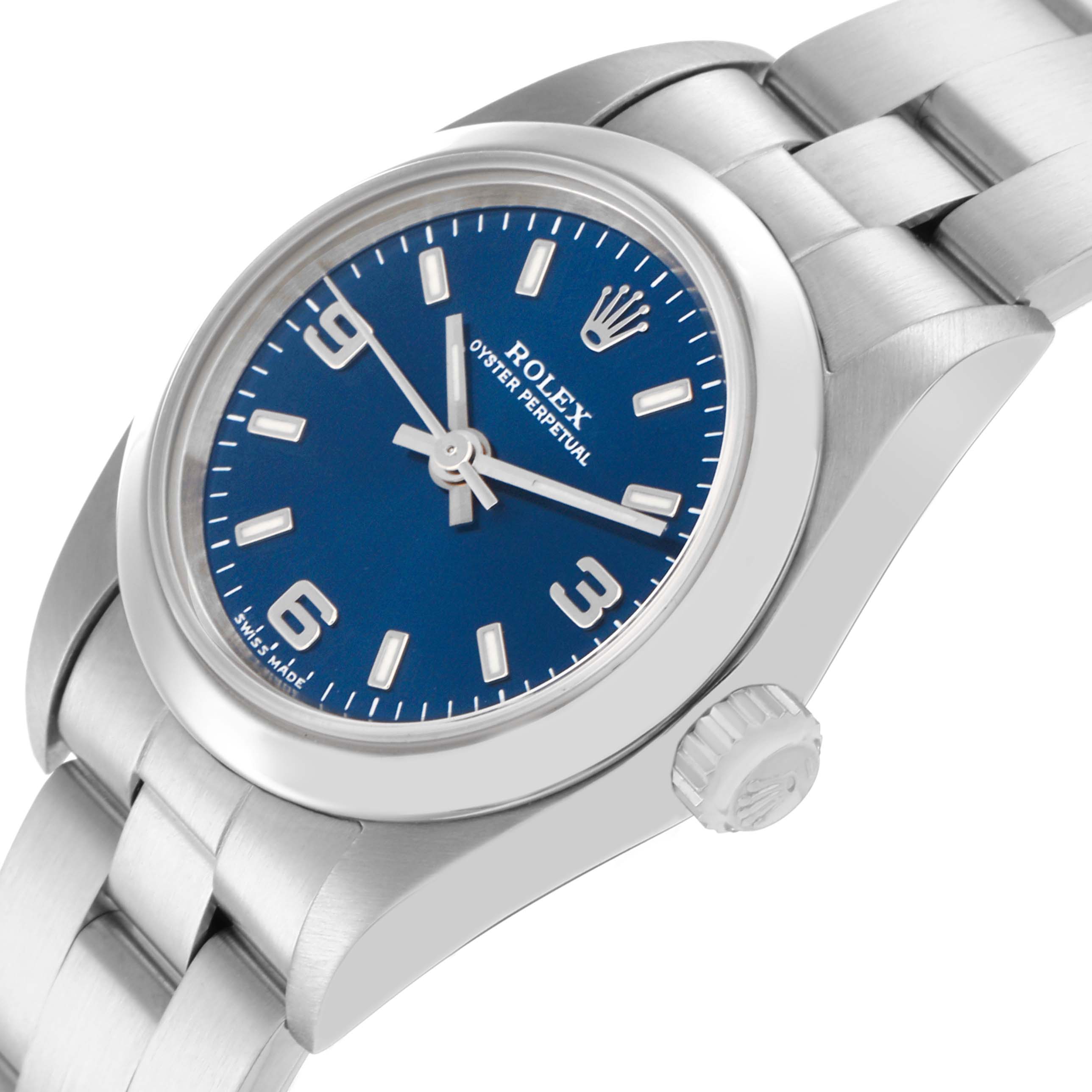 The image shows a Rolex Oyster Perpetual 76080 Women
s Stainless Steel Blue Dial 76080 Women
s Stainless Steel Blue Dial watch at an oblique angle, showcasing the blue dial, crown, and part of the bracelet.