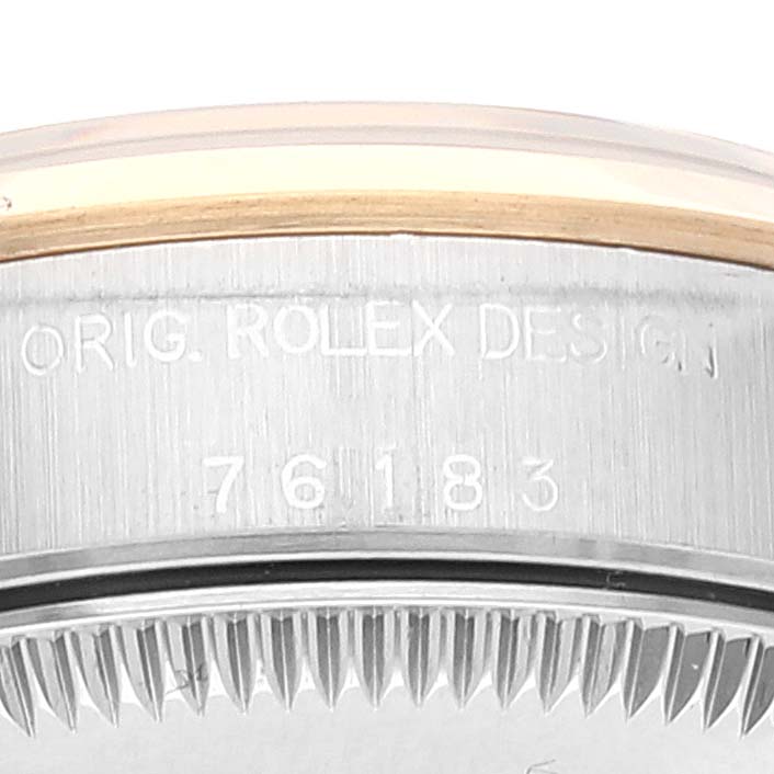The image shows the side view of the bezel and part of the case of the Rolex Oyster Perpetual 76183 Women
s Steel and Gold (two tone) Grey Dial 76183 Women
s Steel and Gold (two tone) Grey Dial watch, detailing the model number 76183.