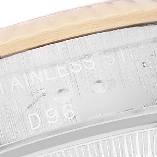 This close-up angle of the Rolex Oyster Perpetual 76193 Women's Steel and Gold (two tone) Silver Dial 76193 Women's Steel and Gold (two tone) Silver Dial watch shows part of the watch's bezel and engraved serial number.