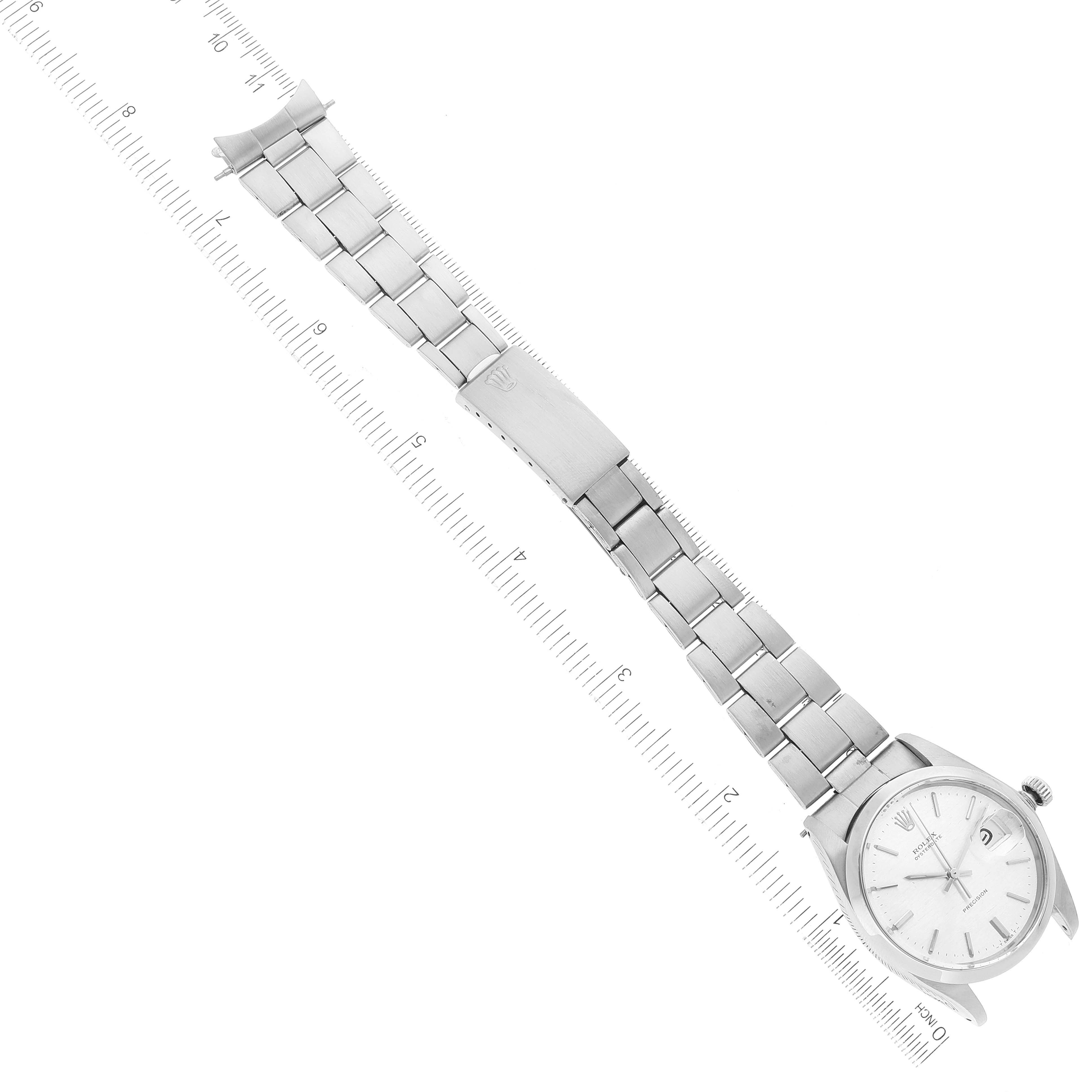 This image displays an aerial view of the Rolex Vintage Collection 6694 Men's Stainless Steel Silver Dial 6694 Men's Stainless Steel Silver Dial watch, showcasing the full length of its linked bracelet and watch face next to a ruler.