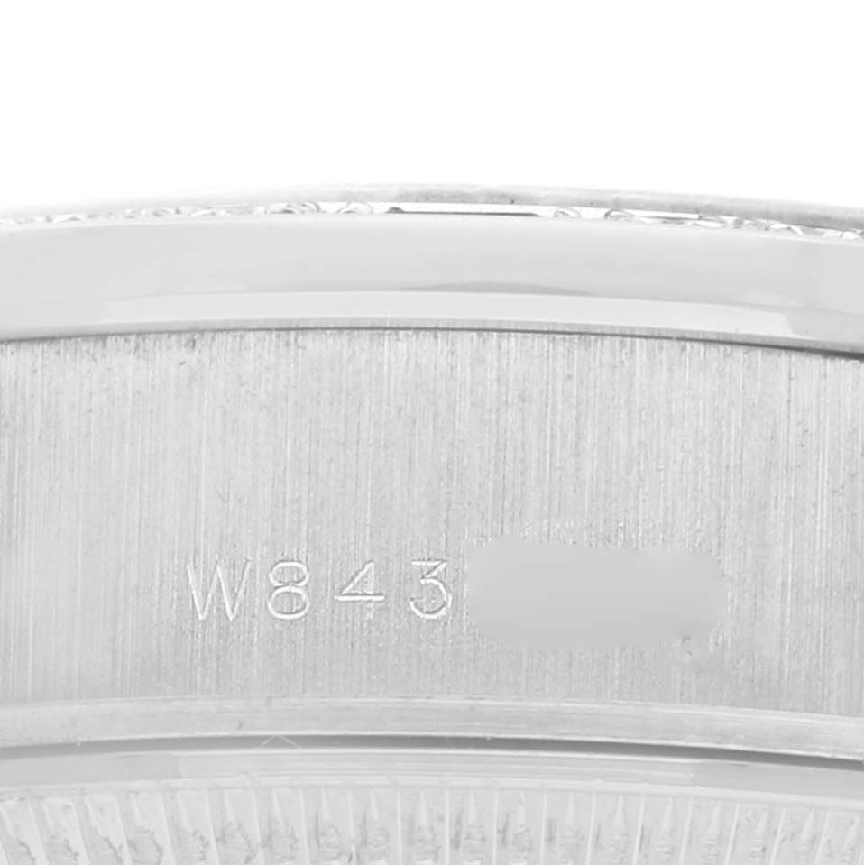 The image shows a close-up of the side of a Rolex President 69079 Women
s White Gold Silver Dial 69079 Women
s White Gold Silver Dial model watch, focusing on the engraved serial number.