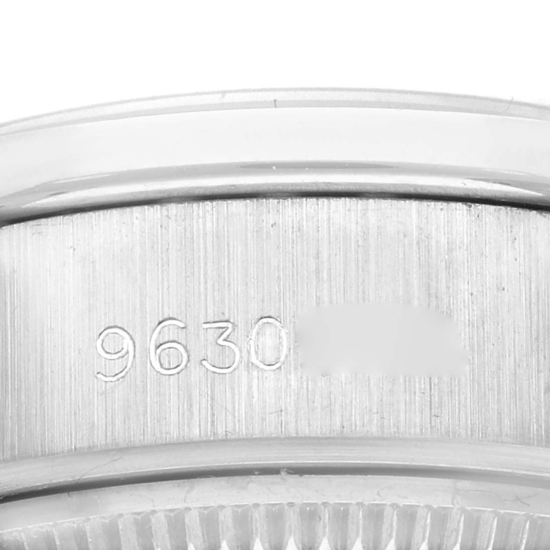 This close-up image shows a partial edge view of the bezel and case of the Rolex President 69139 Women's White Gold Blue Dial 69139 Women's White Gold Blue Dial watch, focusing on an engraved serial number.