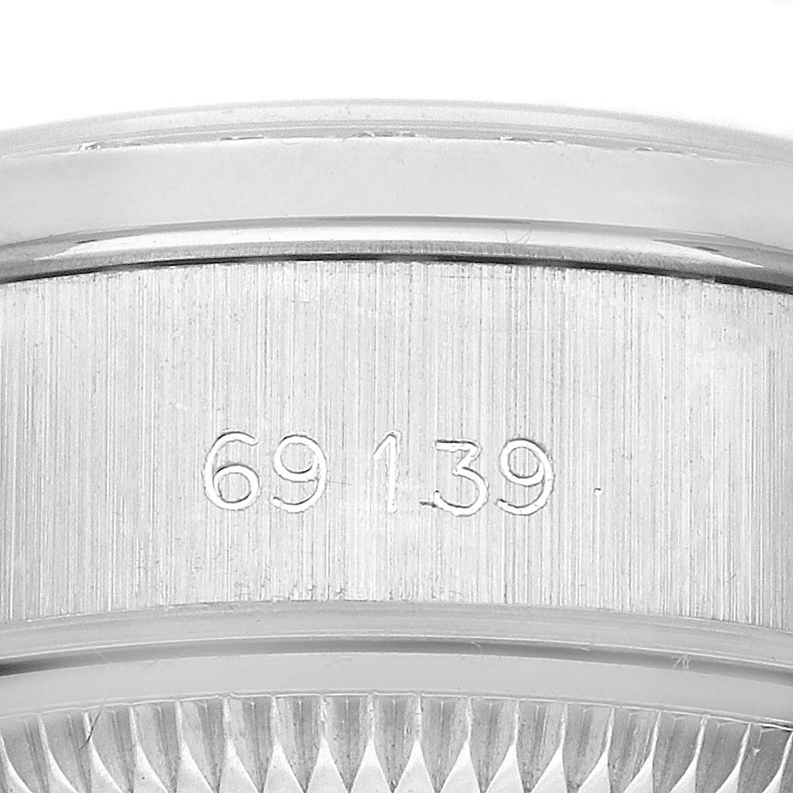 The image shows a close-up of the serial number engraved on the side of the bezel of a Rolex President 69139 Women's White Gold Blue Dial 69139 Women's White Gold Blue Dial model watch.