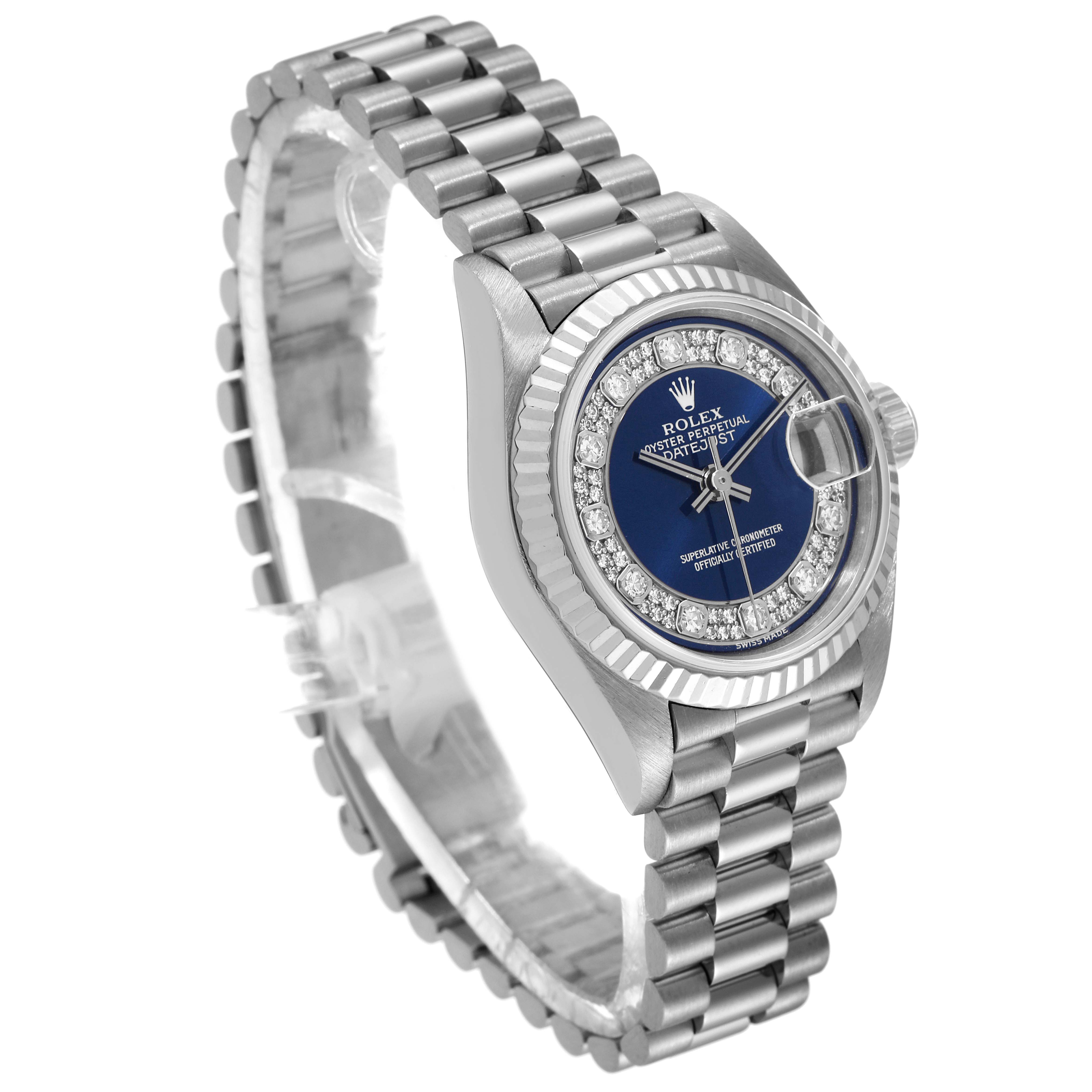 This image shows a Rolex President 69179 Women's White Gold Blue Dial 69179 Women's White Gold Blue Dial model watch from a three-quarter angle, highlighting its blue dial, diamond bezel, and metal bracelet.