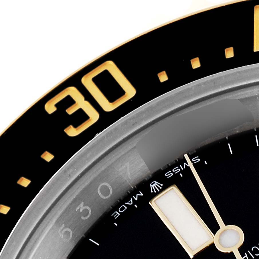 This close-up image of a Rolex Sea-Dweller 126603 Men
s Steel and Gold (two tone) Black Dial 126603 Men
s Steel and Gold (two tone) Black Dial watch shows the bezel with the 30-minute marker and part of the watch face.