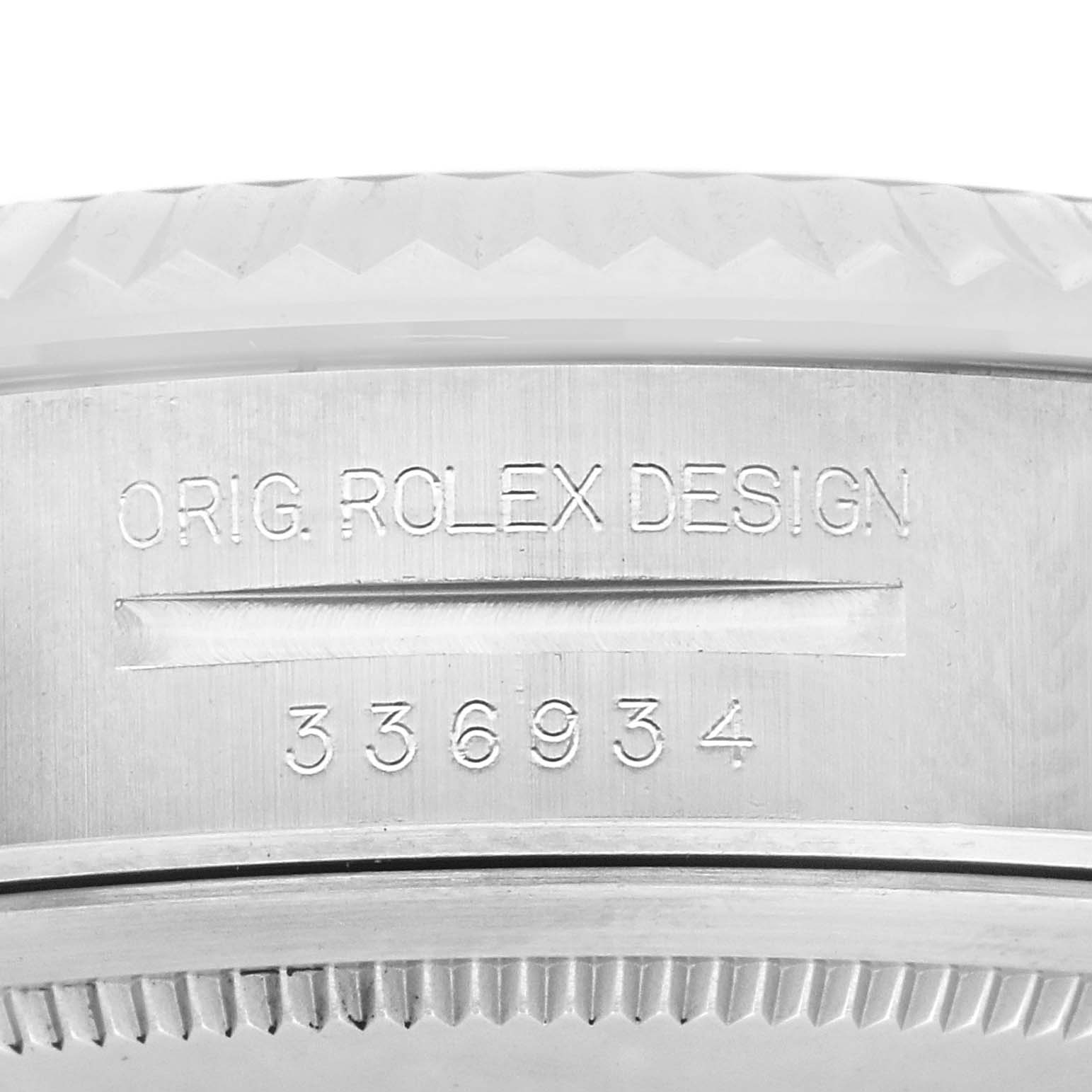 The image shows a close-up of the side of a Rolex Sky-Dweller 336934 Men
s Stainless Steel Black Dial 336934 Men
s Stainless Steel Black Dial watch, focusing on the etched serial number and bezel edge.