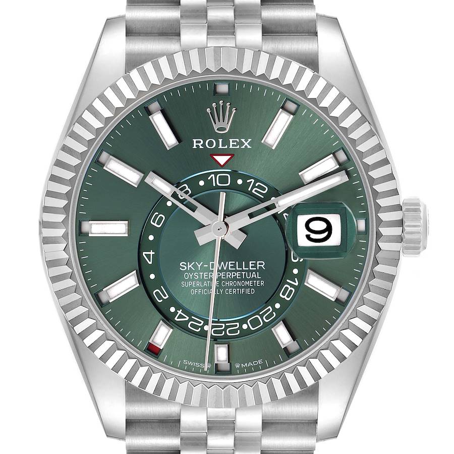 The image shows a front view of the Rolex Sky-Dweller watch, highlighting its green dial, fluted bezel, and date display.