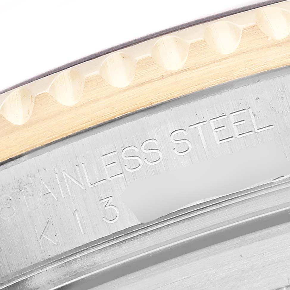 The image shows a close-up of the Rolex Submariner 16613 Men
s Steel and Gold (two tone) Champagne Dial 16613 Men
s Steel and Gold (two tone) Champagne Dial
s bezel edge and the engraved stainless steel case back.