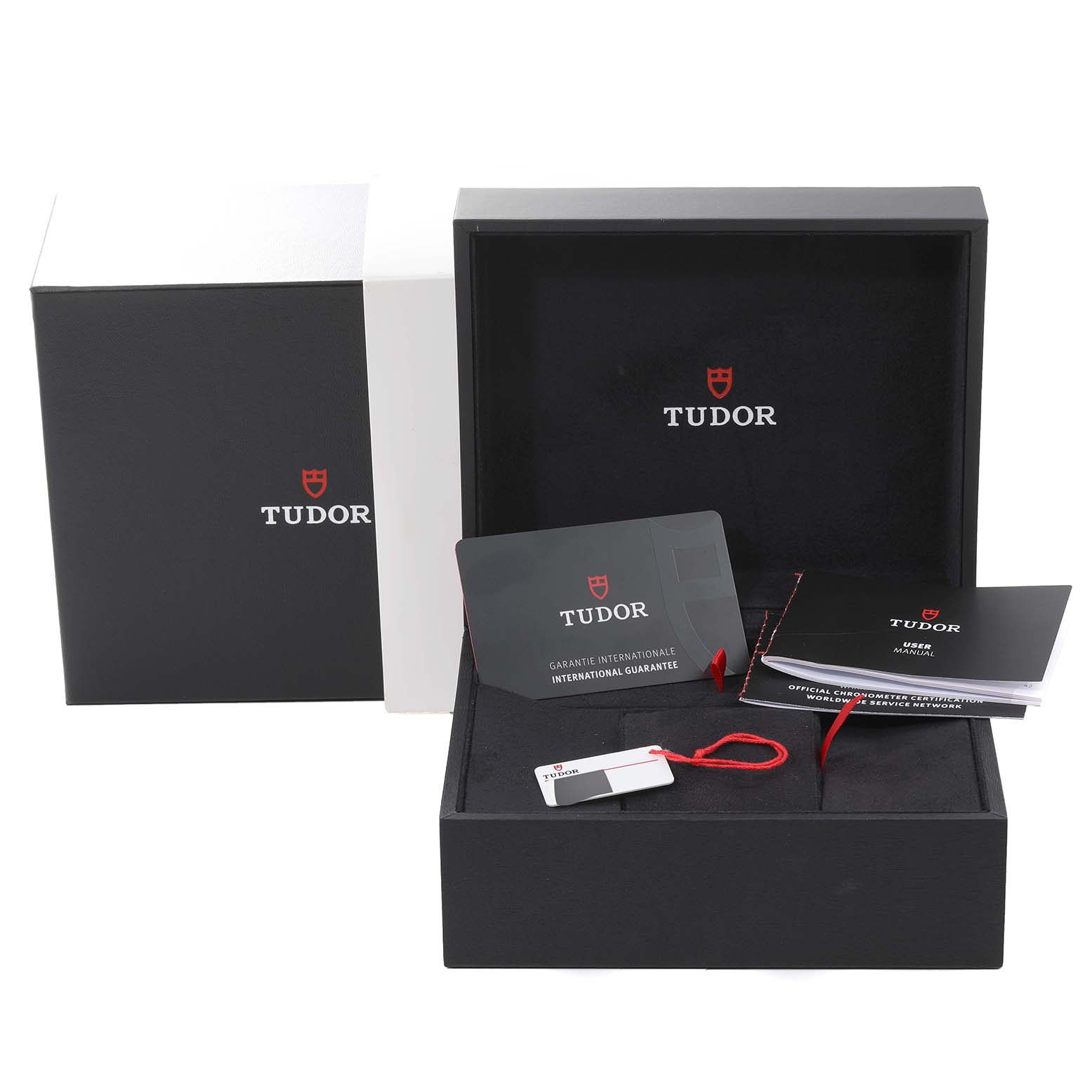 The image shows the Tudor Heritage Black Bay M79000N-0002 Men
s Stainless Steel Black Dial M79000N-0002 Men
s Stainless Steel Black Dial packaging with its warranty card, user manual, and tag from a frontal angle.