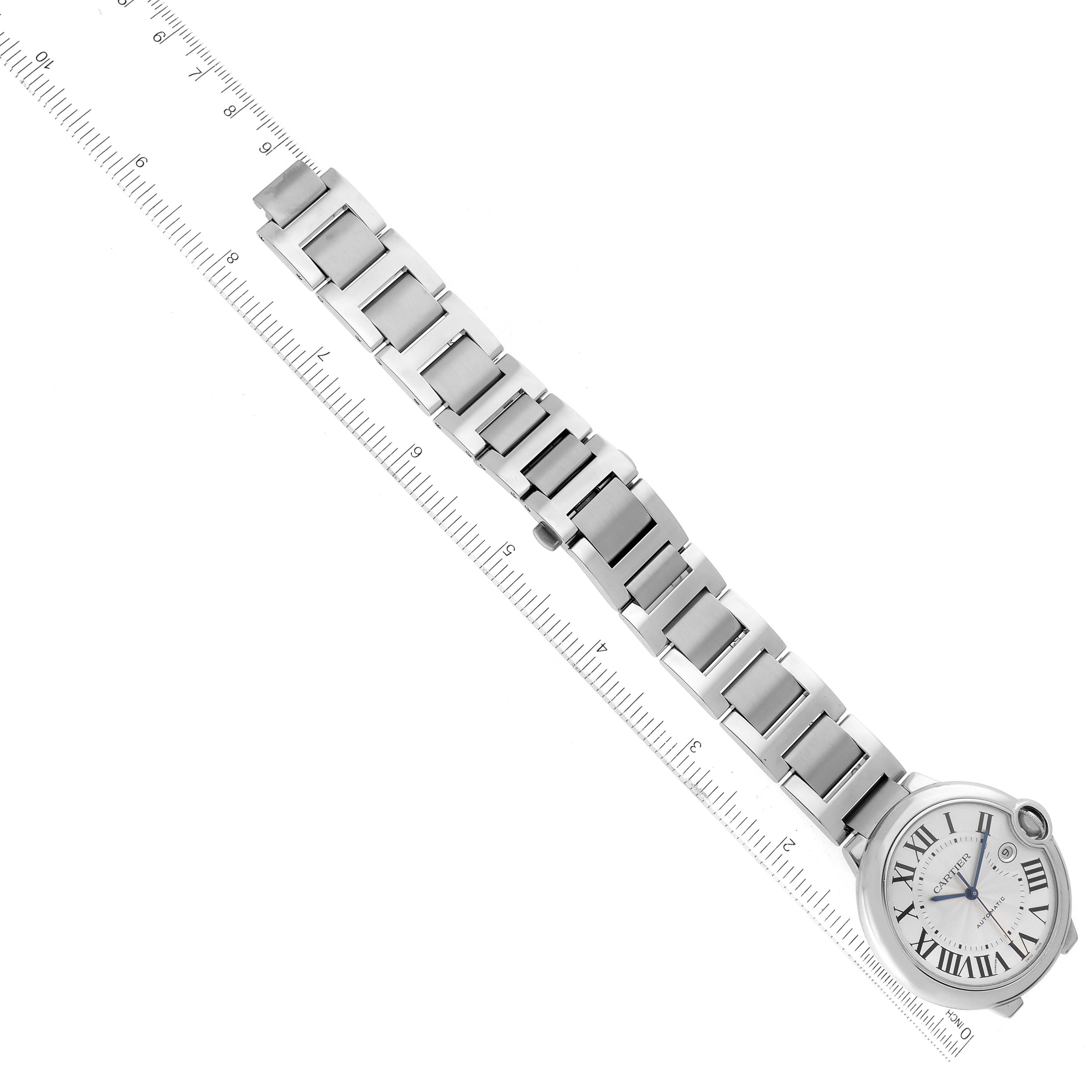 The image shows a top-down view of a Ballon Bleu by Cartier watch, displaying its face, bracelet, and clasp alongside a ruler.
