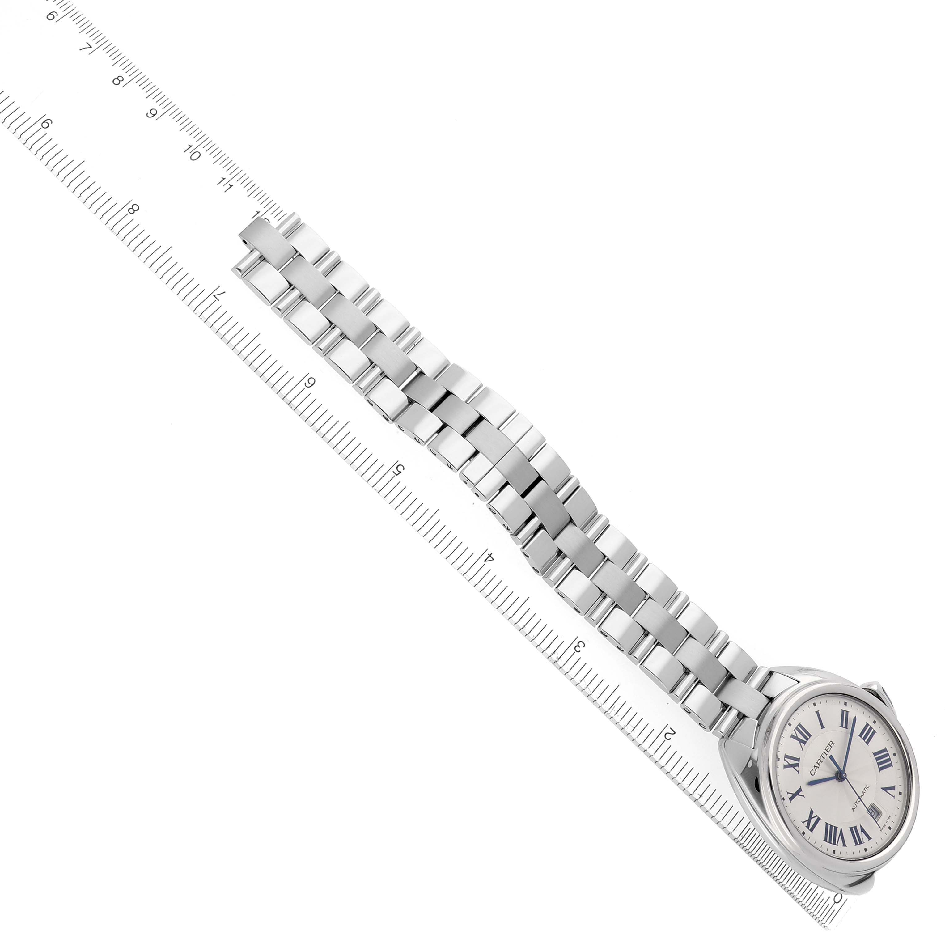 The Cartier Clé watch is shown at an angled side view with a clear view of the metal bracelet and dial.