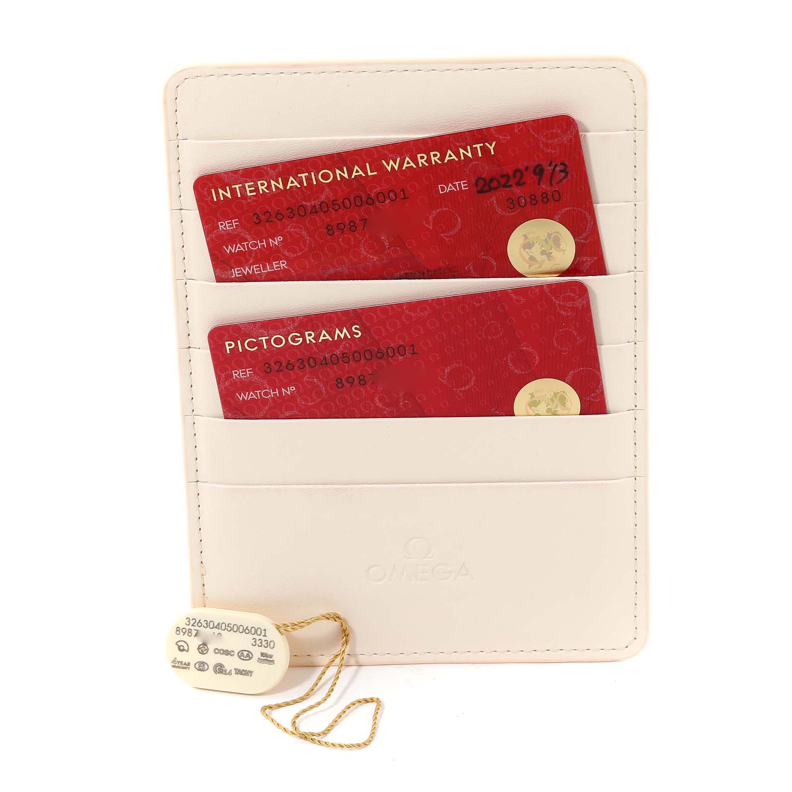 The image shows the warranty and pictogram cards in a holder along with a tag for the Omega Speedmaster 326.30.40.50.06.001 Men's Stainless Steel Grey Dial 326.30.40.50.06.001 Men's Stainless Steel Grey Dial watch model.