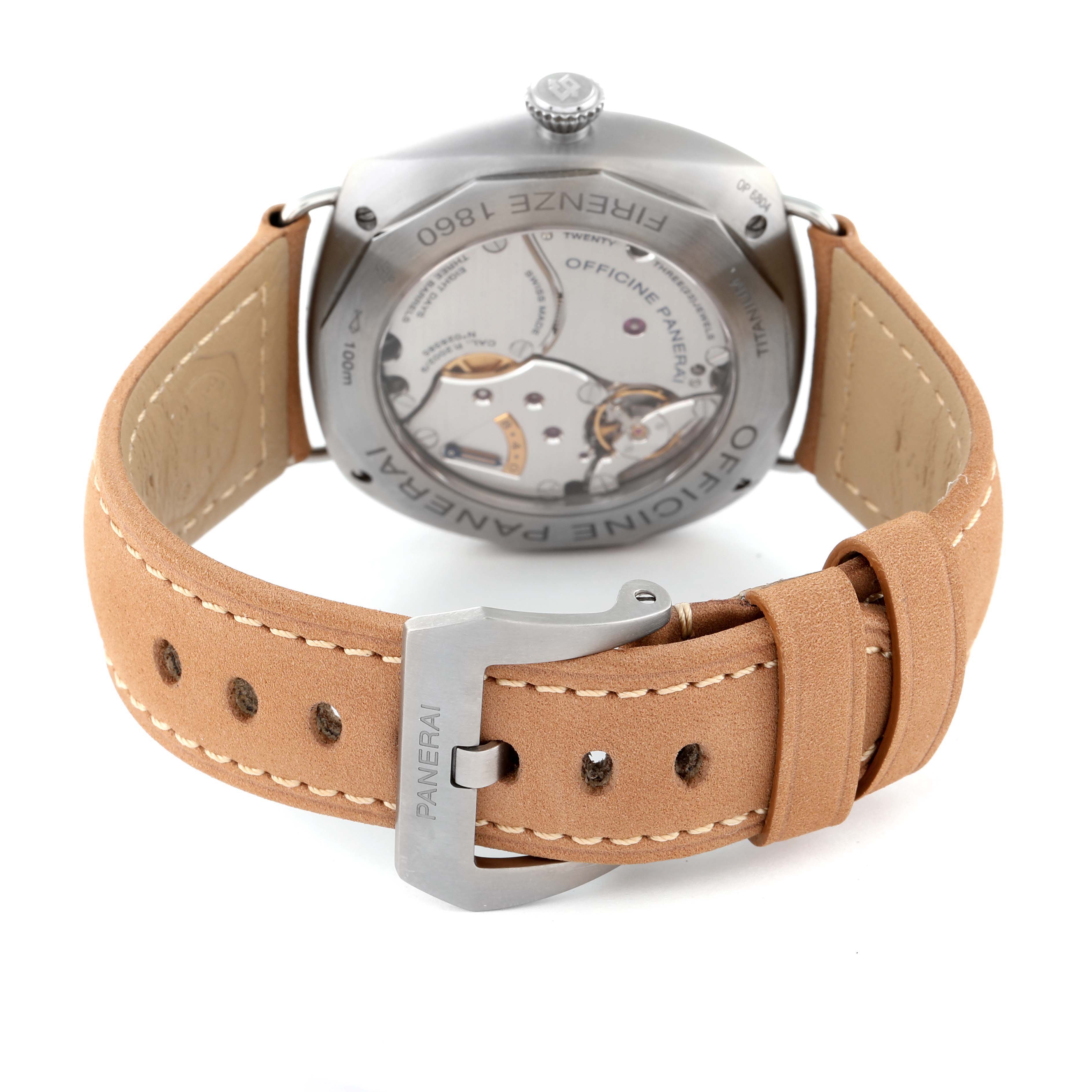 The photo shows the back angle of a Panerai Radiomir PAM00736 Men's Titanium Green Dial PAM00736 Men's Titanium Green Dial watch, displaying its open case back and tan leather strap with buckle.