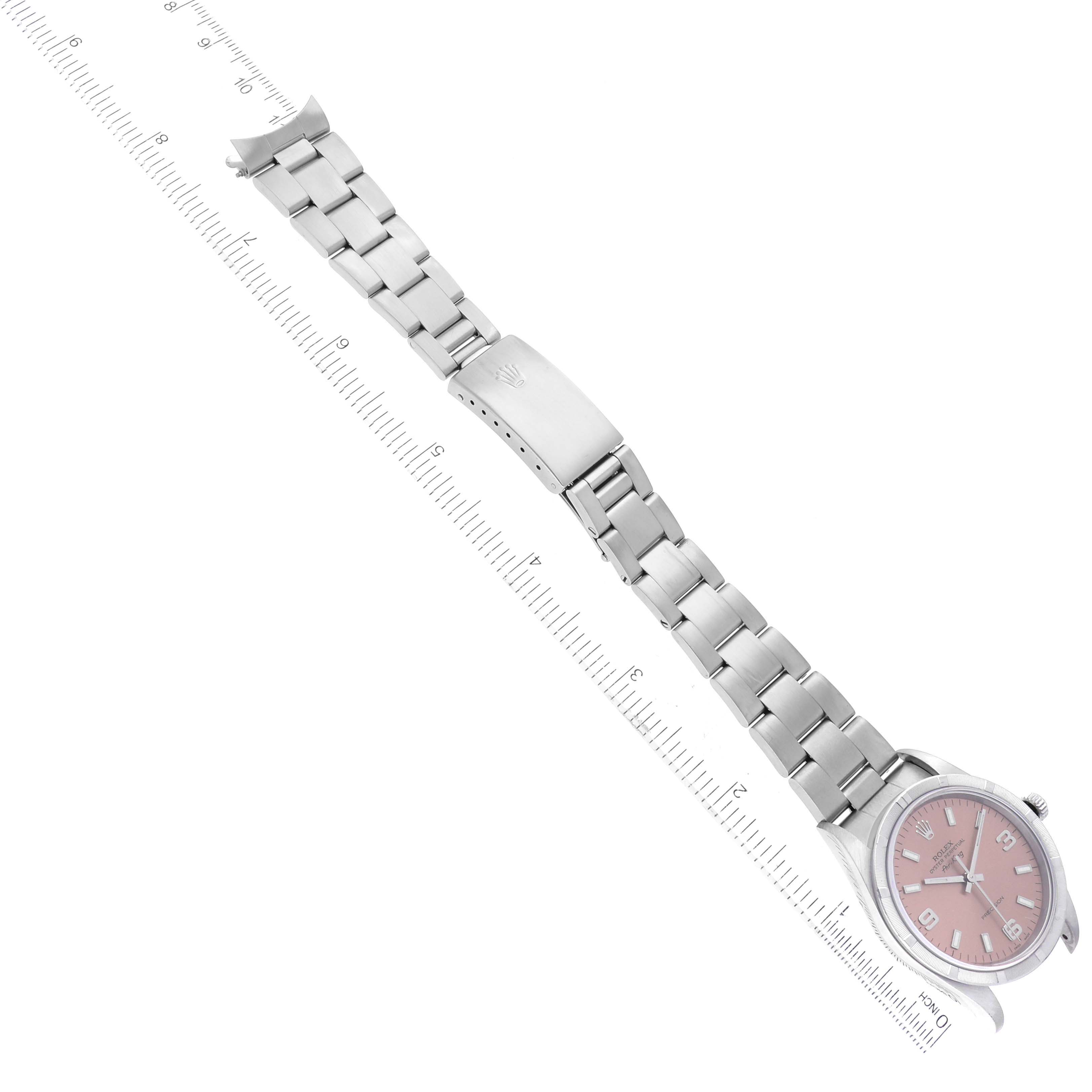 The image shows a full view of a Rolex Air-King 14010 Men's Stainless Steel Pink Dial 14010 Men's Stainless Steel Pink Dial watch placed at a diagonal angle with its metal bracelet fully extended next to a ruler.