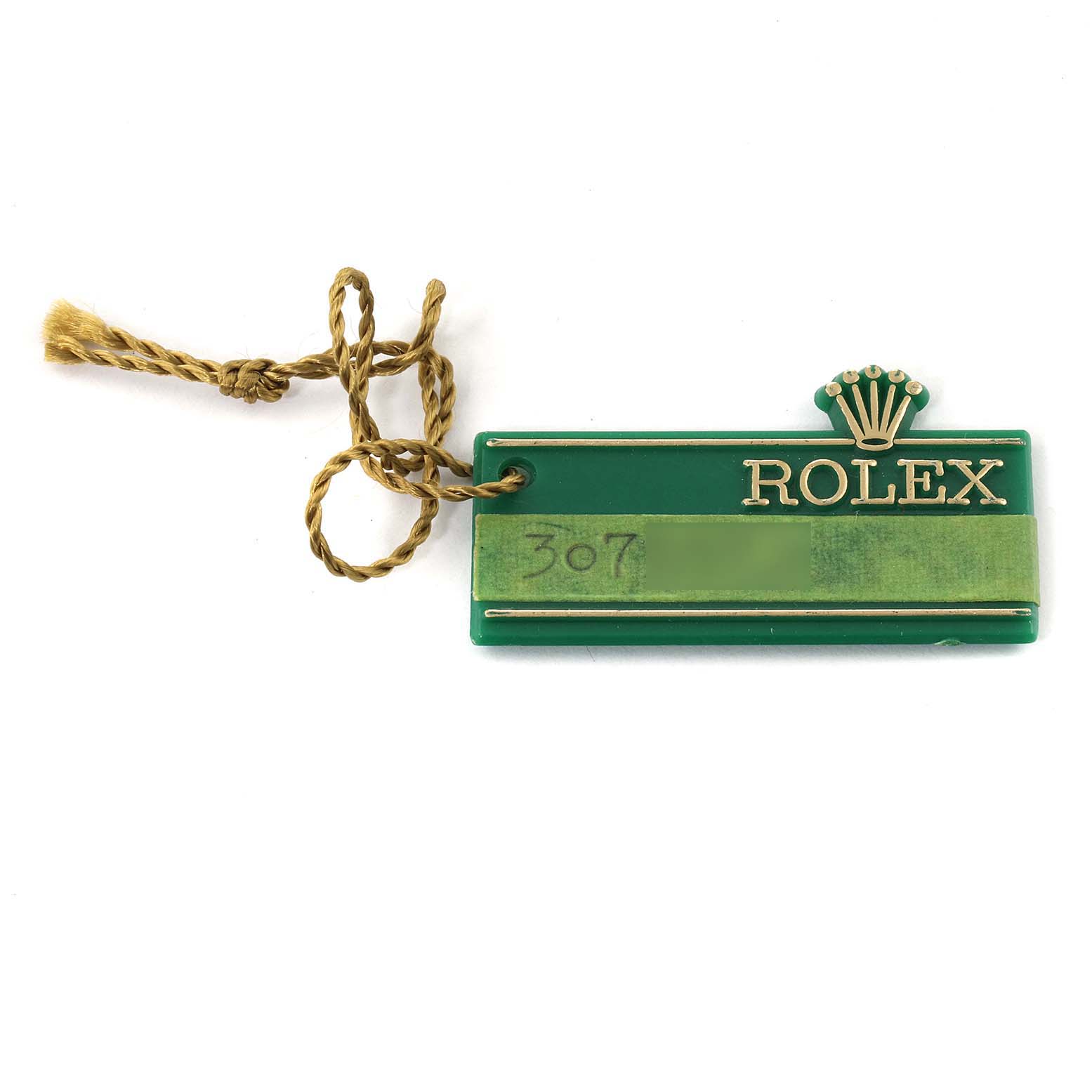 The image shows a green and gold tag accessory for a Rolex Date 6924 Women's Stainless Steel Silver Dial 6924 Women's Stainless Steel Silver Dial model watch, featuring the brand's logo and a braided string.