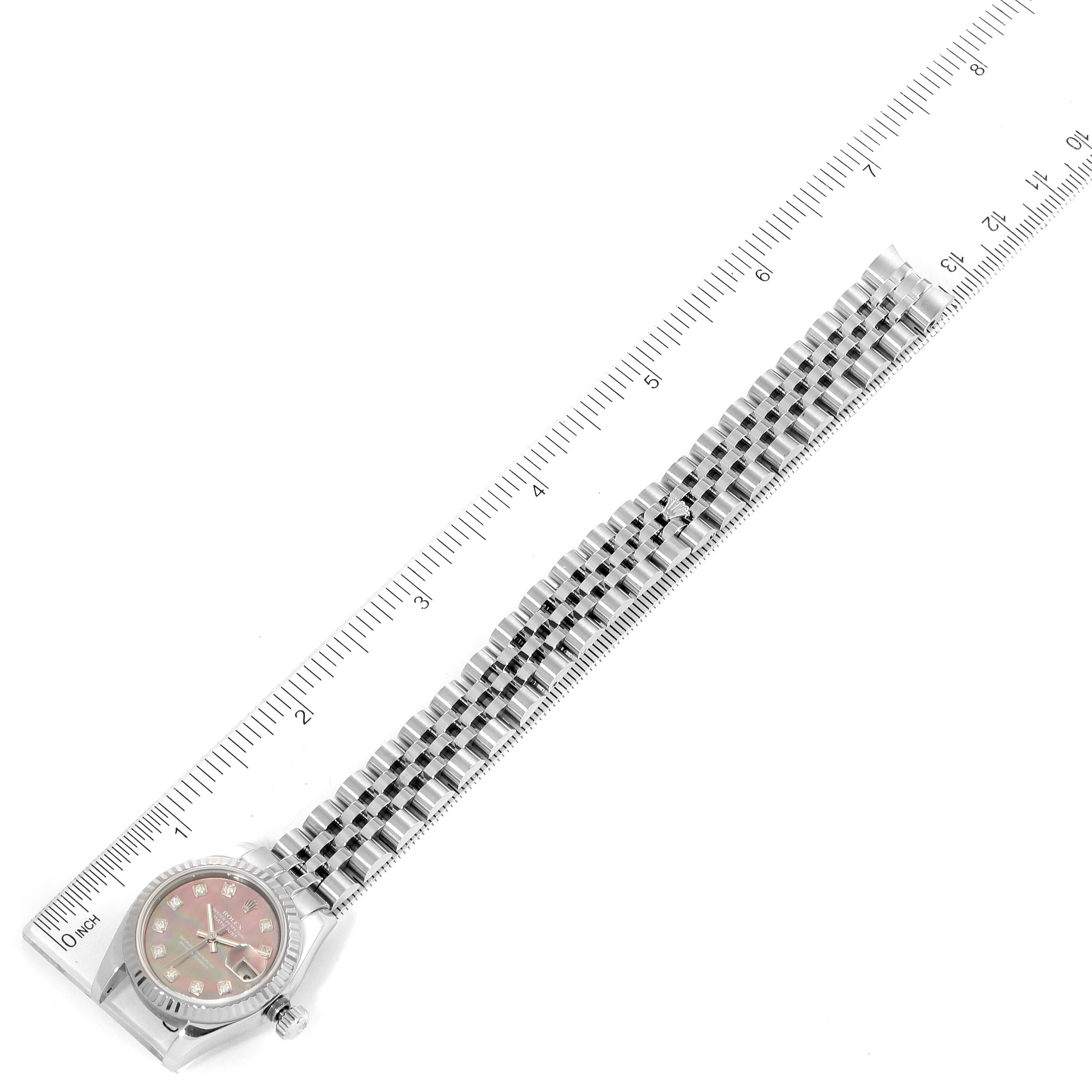 The image shows a top view of a Rolex Datejust 179174 Women
s Stainless Steel Mother of Pearl Dial 179174 Women
s Stainless Steel Mother of Pearl Dial watch with a ruler measuring its length.