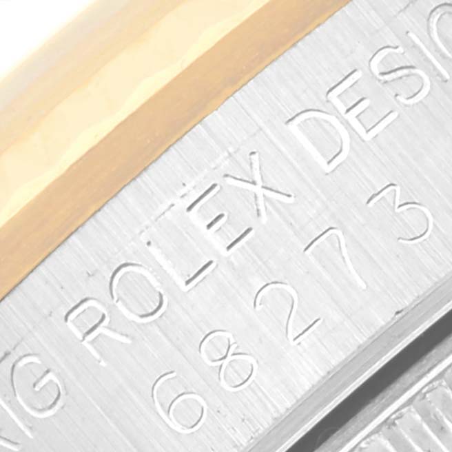 The image shows a close-up of the side of the watch case for a Rolex Mid-Size 68273 Women's Steel and Gold (two tone) White Dial 68273 Women's Steel and Gold (two tone) White Dial model, highlighting the engraved text and part of the bezel.