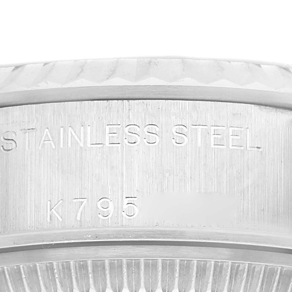 This close-up image shows part of the stainless steel case of a Rolex Datejust 79174 Women's Stainless Steel Silver Dial 79174 Women's Stainless Steel Silver Dial watch engraved with a serial number.