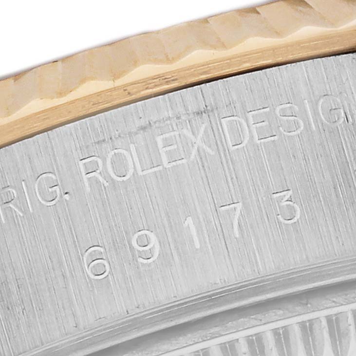 The image shows a close-up of the serial number engraving and the bezel of a Rolex Datejust 69173G Women's Steel and Gold (two tone) Green Dial 69173G Women's Steel and Gold (two tone) Green Dial watch.