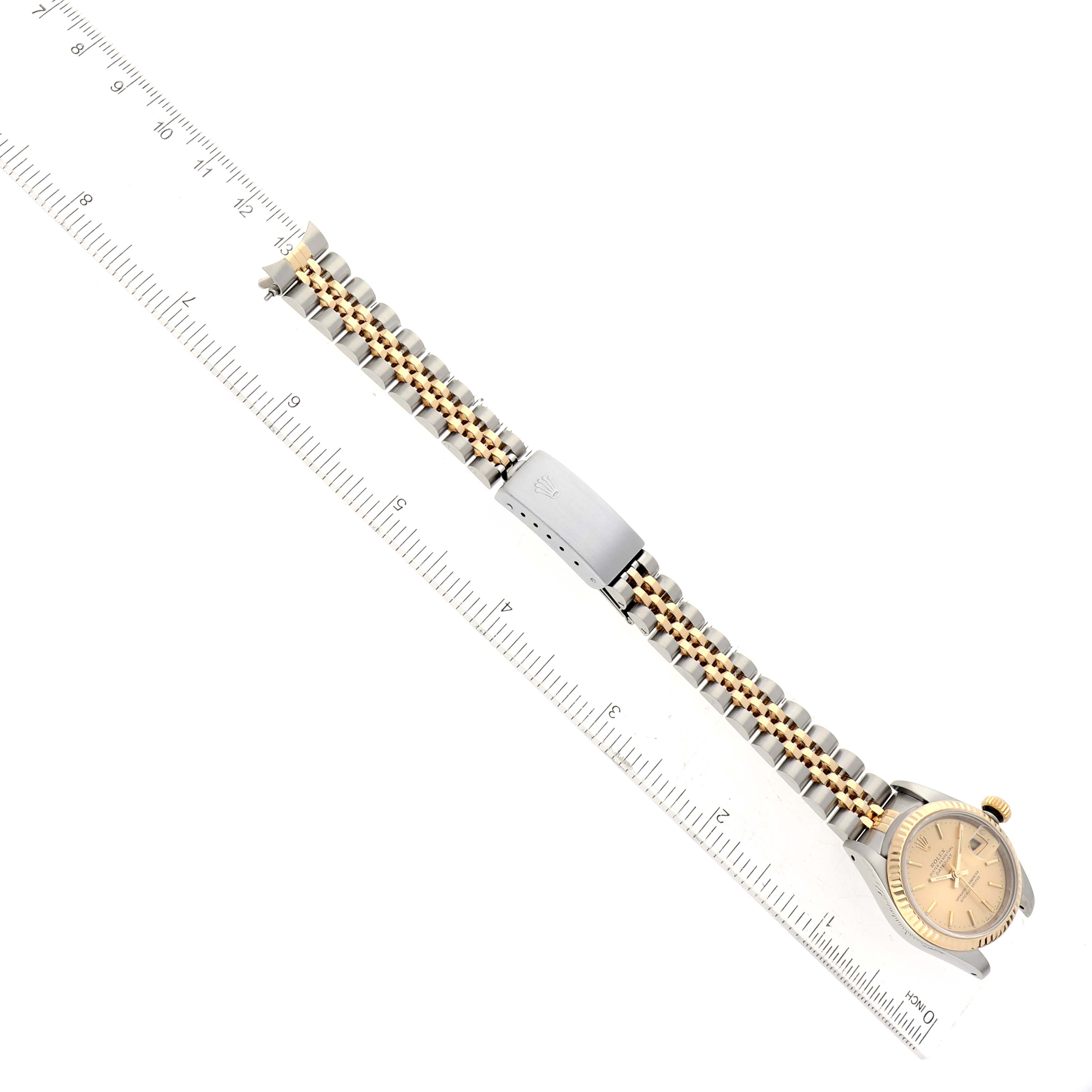 The image shows a Rolex Datejust 69173 Women's Steel and Gold (two tone) Champagne Dial 69173 Women's Steel and Gold (two tone) Champagne Dial watch laid flat with the band extended, positioned next to a ruler for scale.
