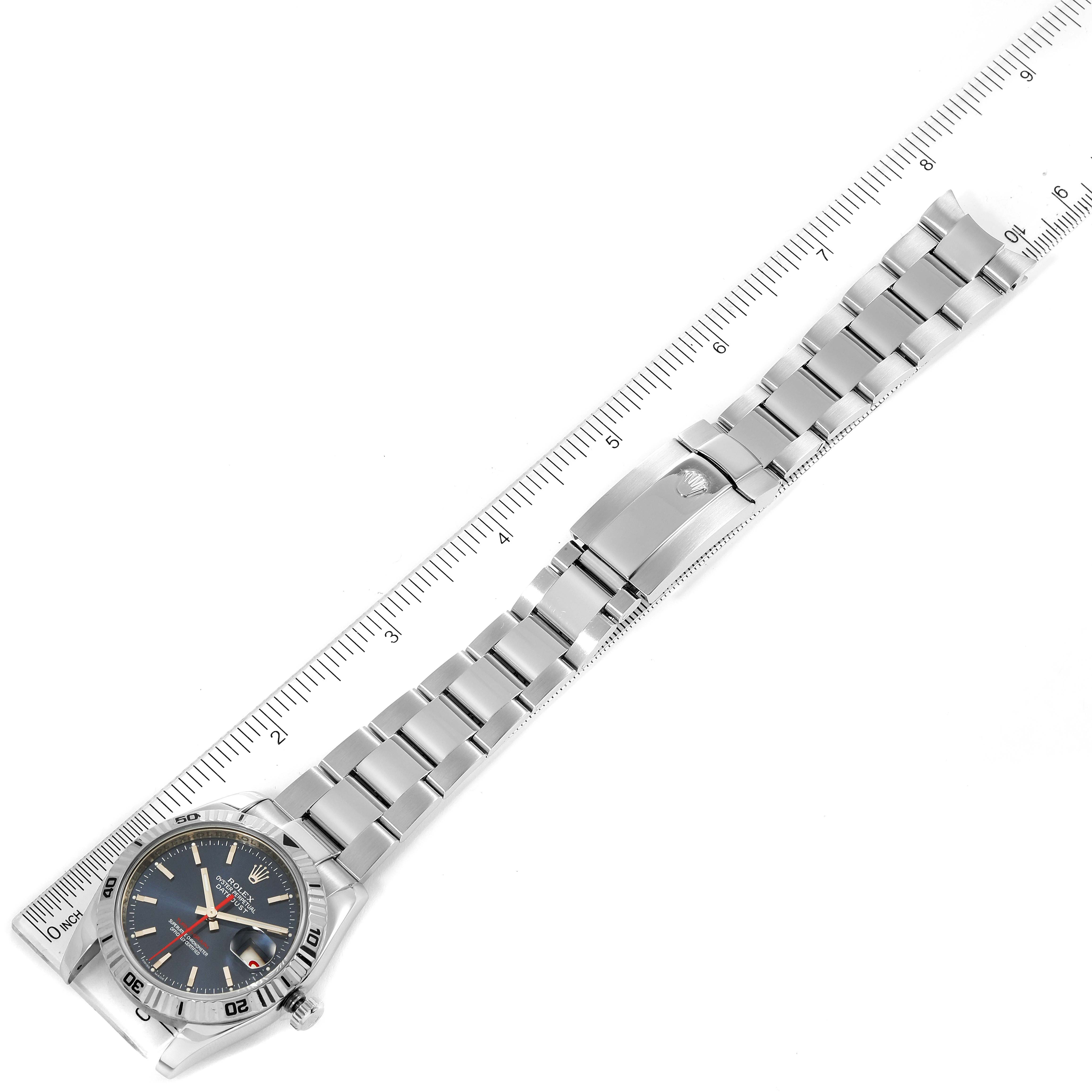 The image shows a full view of the Rolex Turn-o-Graph 116264 Men
s Stainless Steel Blue Dial 116264 Men
s Stainless Steel Blue Dial watch laid flat with a ruler for scale.