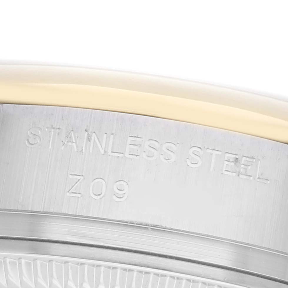 The image shows a close-up of the side view of a Rolex Datejust 179163 Women
s Steel and Gold (two tone) Grey Dial 179163 Women
s Steel and Gold (two tone) Grey Dial, highlighting the stainless steel case with an engraving.