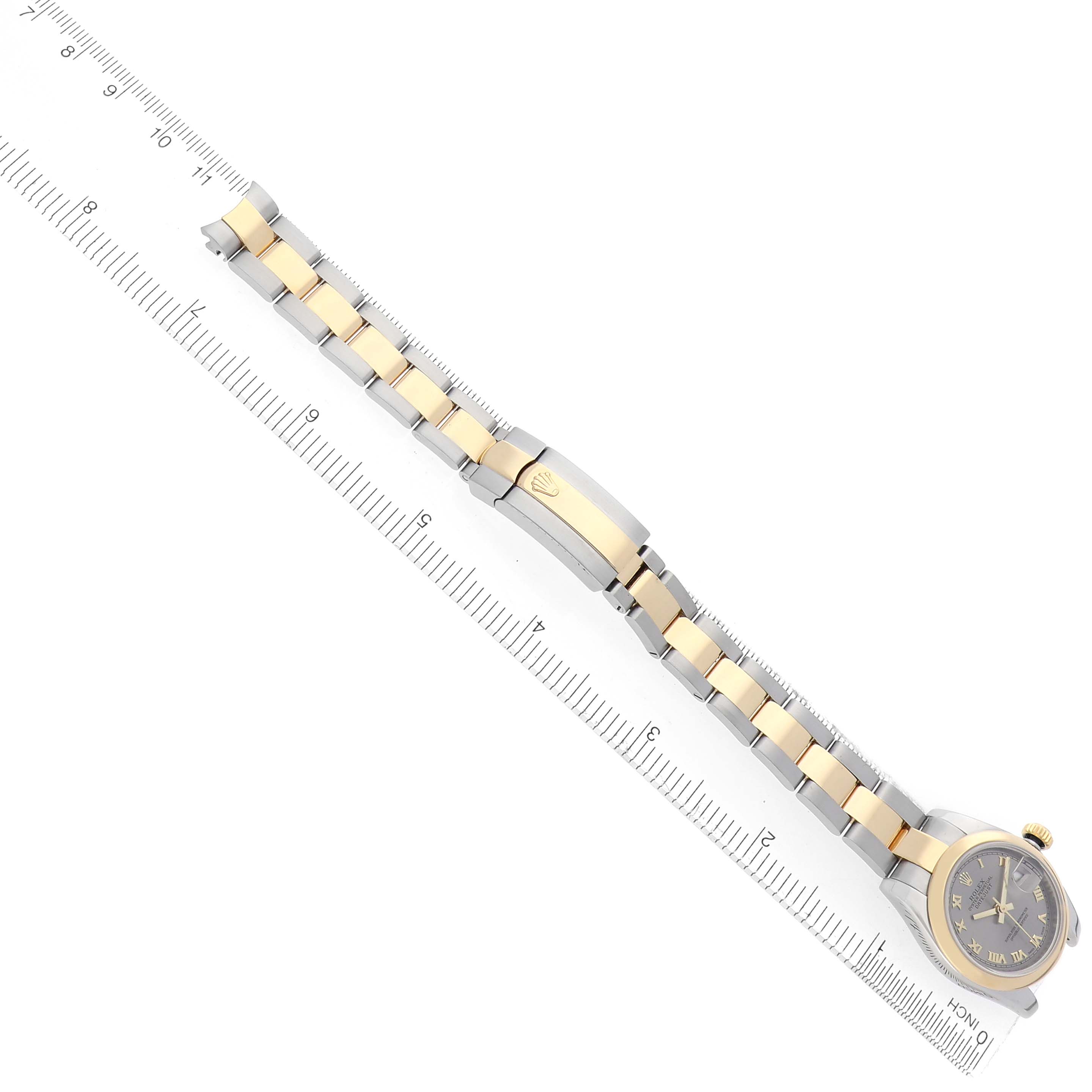 The Rolex Datejust 179163 Women
s Steel and Gold (two tone) Grey Dial 179163 Women
s Steel and Gold (two tone) Grey Dial watch is shown at an angle displaying the full bracelet, clasp, and face, with a ruler for size reference.