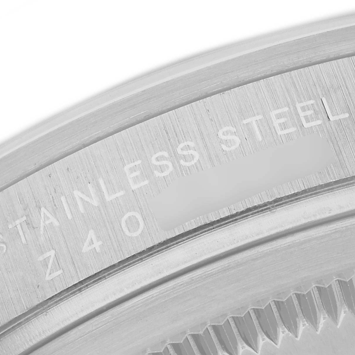 This image shows a close-up of the case back edge of a Rolex Explorer 114270 Men
s Stainless Steel Black Dial 114270 Men
s Stainless Steel Black Dial watch, revealing the stainless steel part and engraved text.