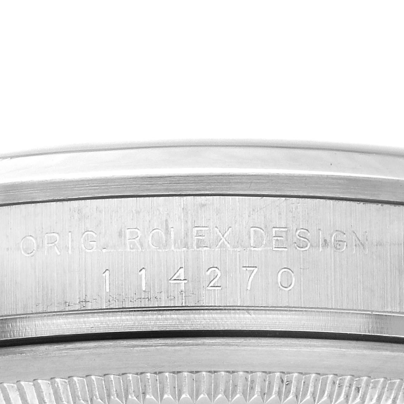 This image shows the engraved side detail on the case of a Rolex Explorer 114270 Men
s Stainless Steel Black Dial 114270 Men
s Stainless Steel Black Dial watch, including model number and "ORIG. ROLEX DESIGN".