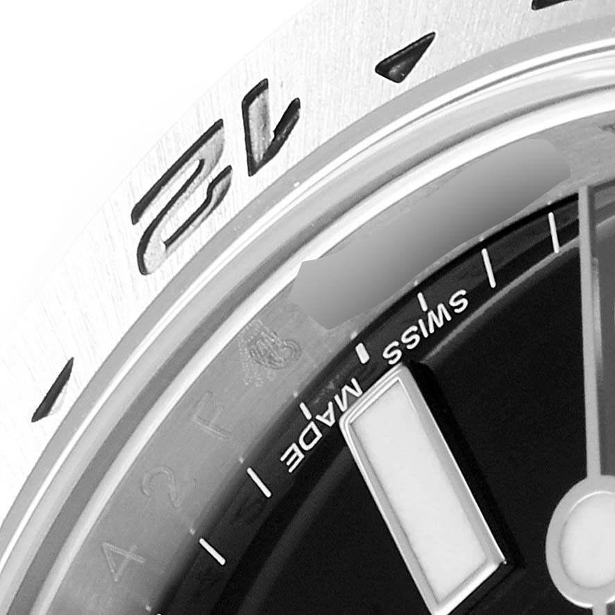 This close-up of a Rolex Explorer 216570 Men's Stainless Steel Black Dial 216570 Men's Stainless Steel Black Dial watch displays the bezel, partial dial, and "SWISS MADE" text.