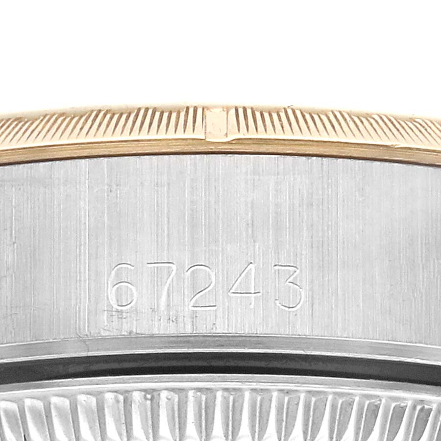 The image shows a close-up of the side of a Rolex Oyster Perpetual 67243 Women
s Steel and Gold (two tone) White Dial 67243 Women
s Steel and Gold (two tone) White Dial watch, focusing on the engraved model number and part of the bezel.