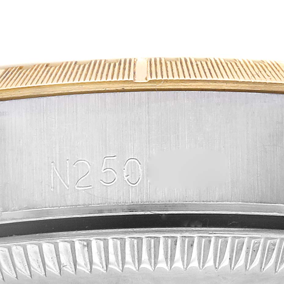 The image shows a close-up view of the Rolex Oyster Perpetual 67243 Women
s Steel and Gold (two tone) White Dial 67243 Women
s Steel and Gold (two tone) White Dial
s case side and bezel with engravings.