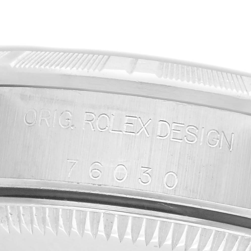 The image shows a close-up of the case side of a Rolex Oyster Perpetual 76030 Women's Stainless Steel Pink Dial 76030 Women's Stainless Steel Pink Dial, highlighting the engravings and part of the bezel.