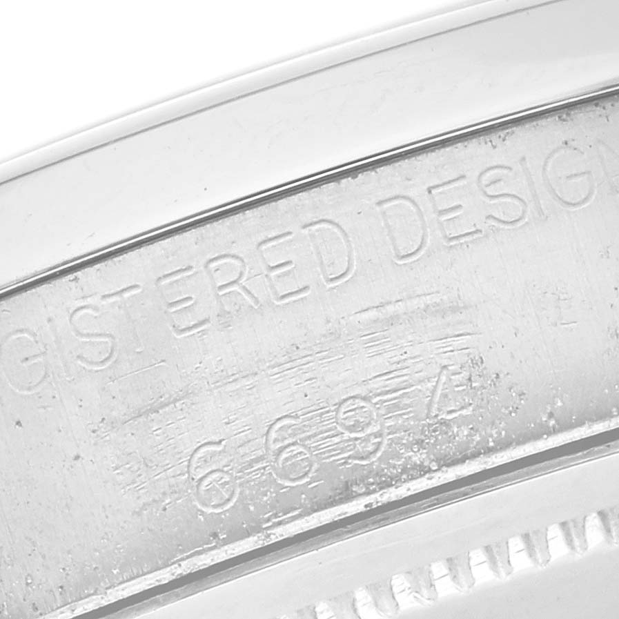The image shows a close-up of the side with engraved text on a Rolex Vintage Collection 6694 Men
s Stainless Steel Silver Dial 6694 Men
s Stainless Steel Silver Dial watch.