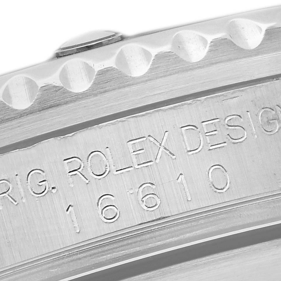 Close-up shot of the Rolex Submariner 16610 Men
s Stainless Steel Black Dial 16610 Men
s Stainless Steel Black Dial
s case edge, showing the "ORIG. ROLEX DESIGN 16610" engraving.