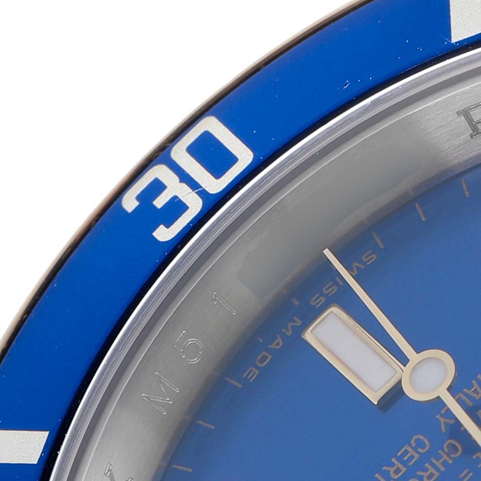 The image shows a close-up of the Rolex Submariner 16613 Men
s Steel and Gold (two tone) Blue Dial 16613 Men
s Steel and Gold (two tone) Blue Dial
s bezel, partial dial, and minute hand.