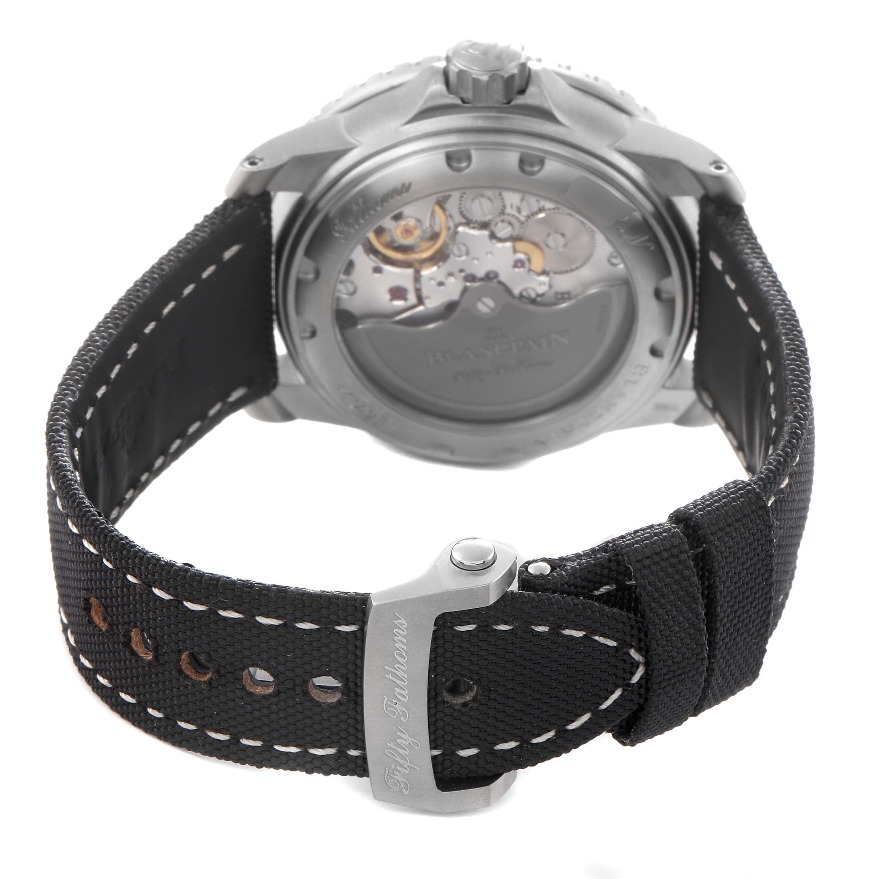 The image shows the back of a Blancpain Fifty Fathoms 5015-12B30 Men
s Titanium Black Dial 5015-12B30 Men
s Titanium Black Dial watch, highlighting the movement through the transparent case back and the secured strap.