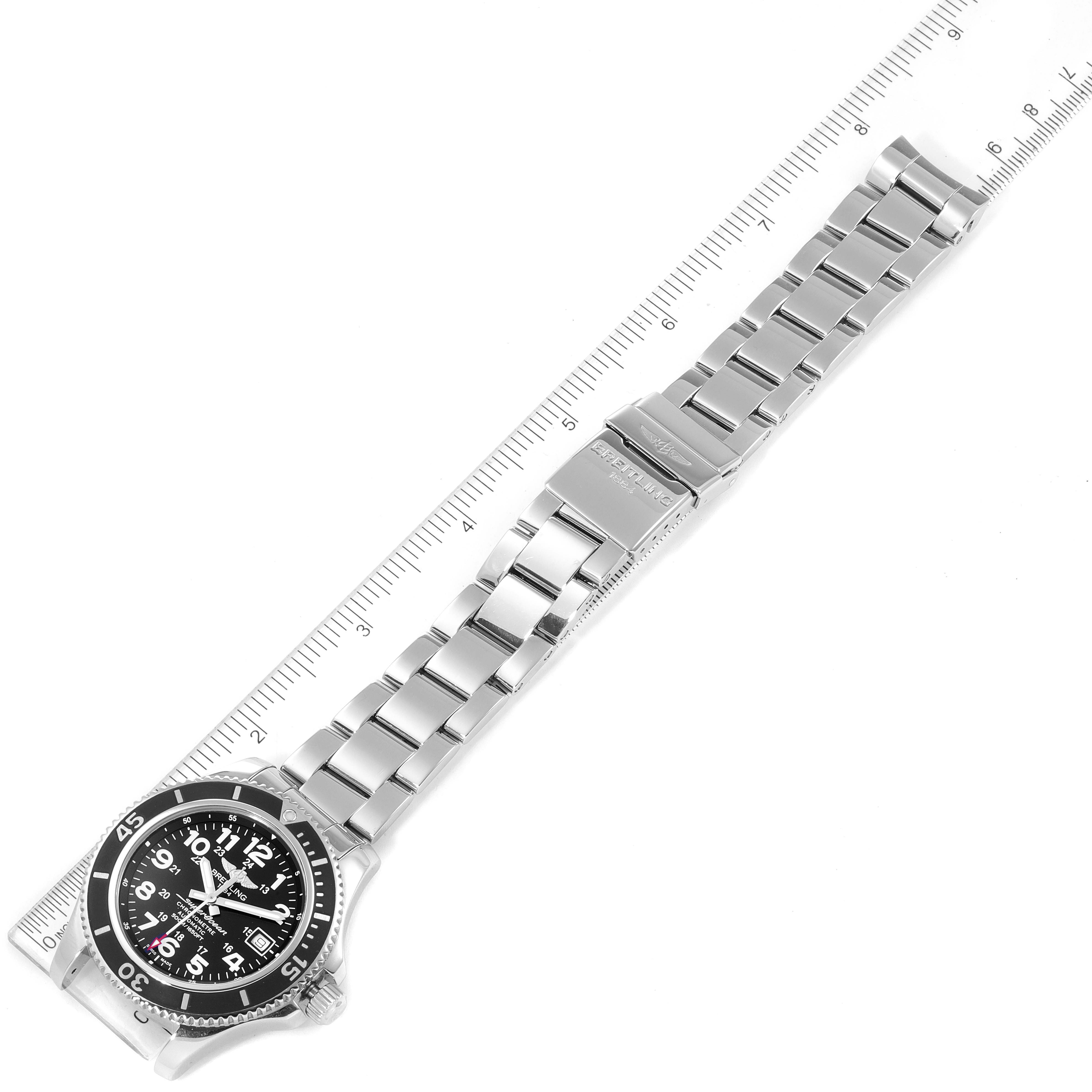 The Breitling Superocean A17365 Men
s Stainless Steel Black Dial A17365 Men
s Stainless Steel Black Dial watch is shown from a top-down angle, displaying its face and stainless steel bracelet against a ruler.