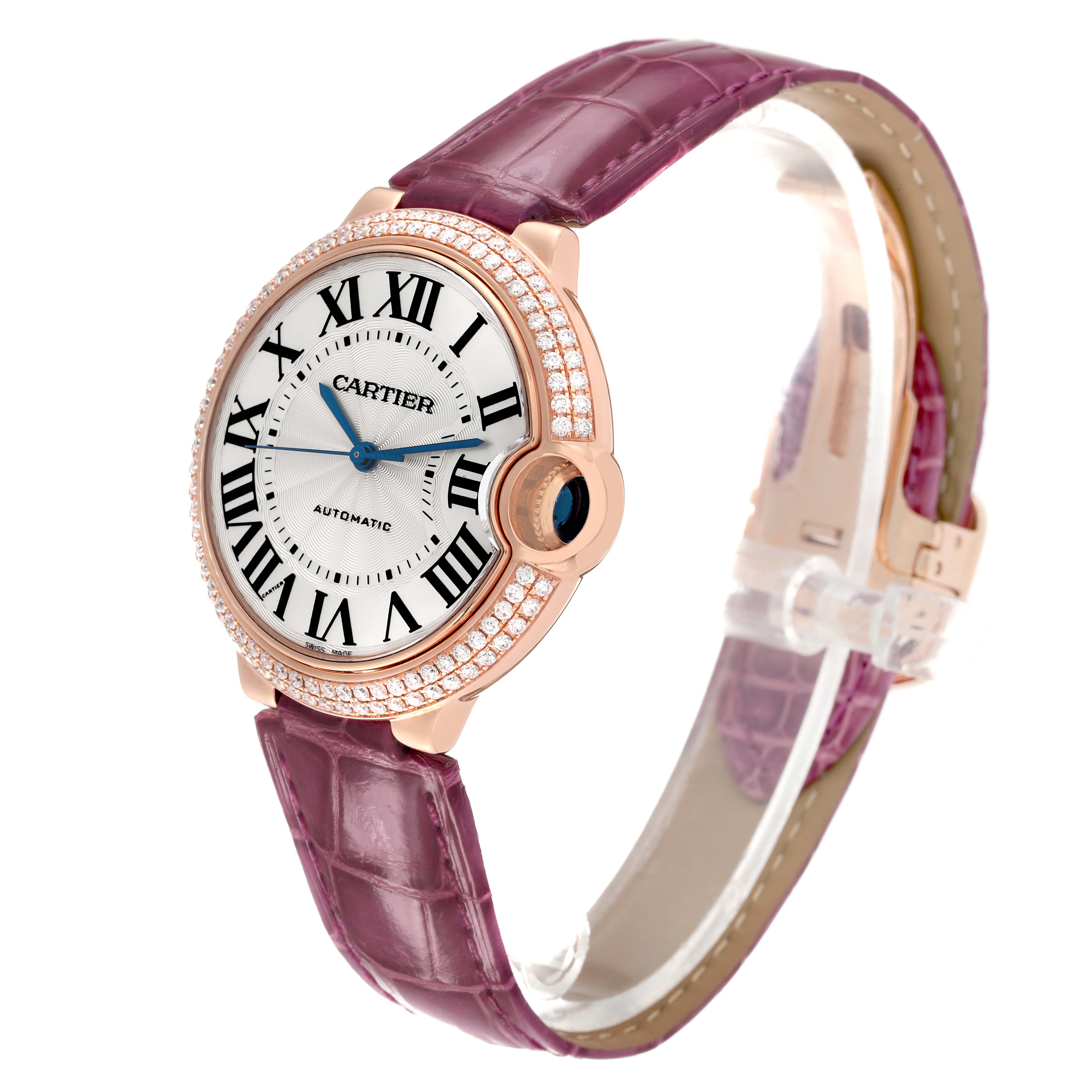 The Cartier Ballon Bleu WE900551 Men's Rose Gold Silver Dial watch is shown at a slight angle, highlighting the face, Roman numerals, diamond bezel, and purple strap.