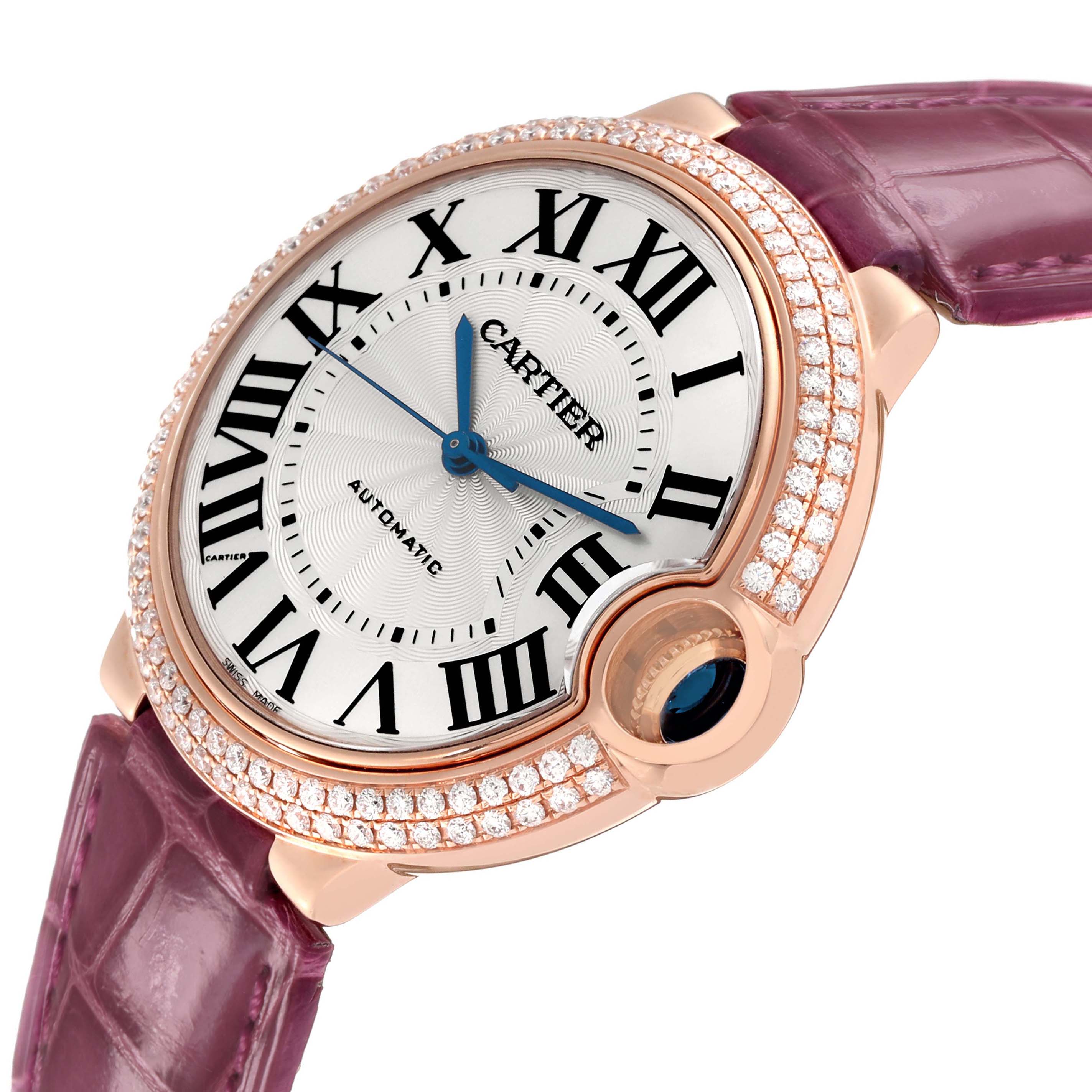 The Cartier Ballon Bleu WE900551 Men's Rose Gold Silver Dial watch is shown in a close-up angle, highlighting its diamond-set bezel, silver dial, and purple strap.