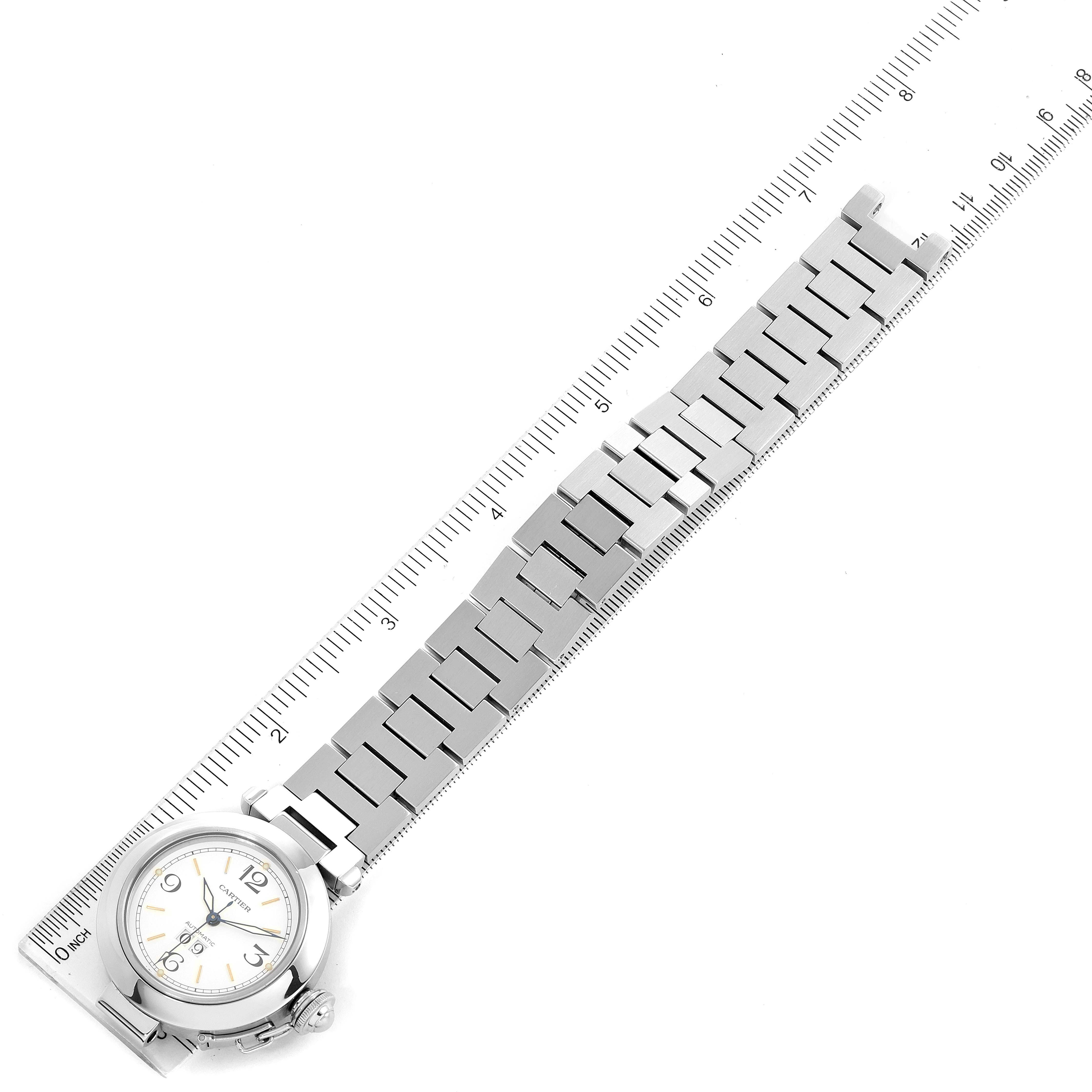 The image shows a Cartier Pasha W31044M7 Men's Stainless Steel White Dial W31044M7 Men's Stainless Steel White Dial model watch laid flat next to a ruler, displaying the entire watch and bracelet.